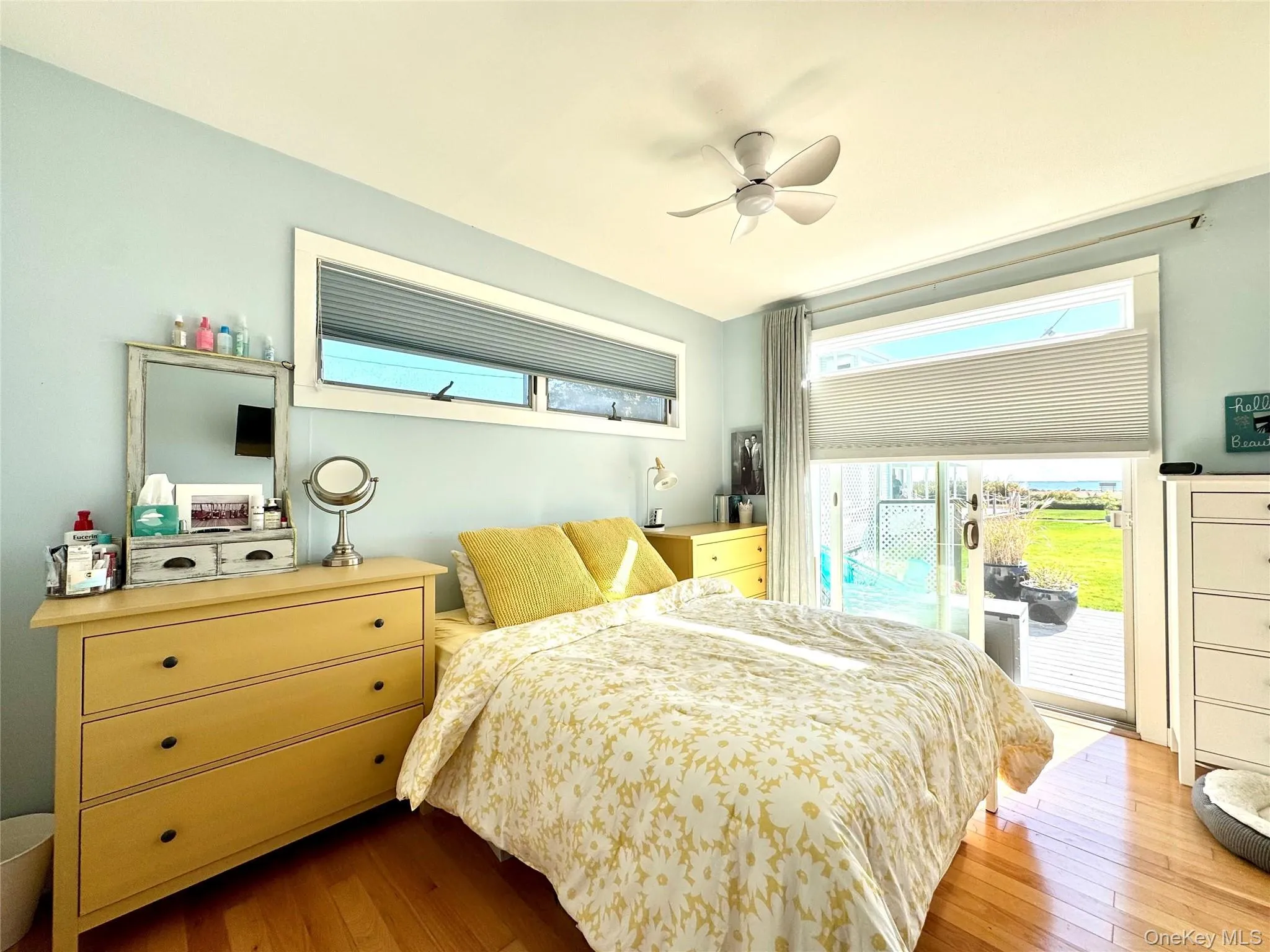 Bedroom featuring access to exterior, wood-type flooring, and a ceiling fan Bedroom featuring access to exterior, wood-type flooring, and a ceiling fan
