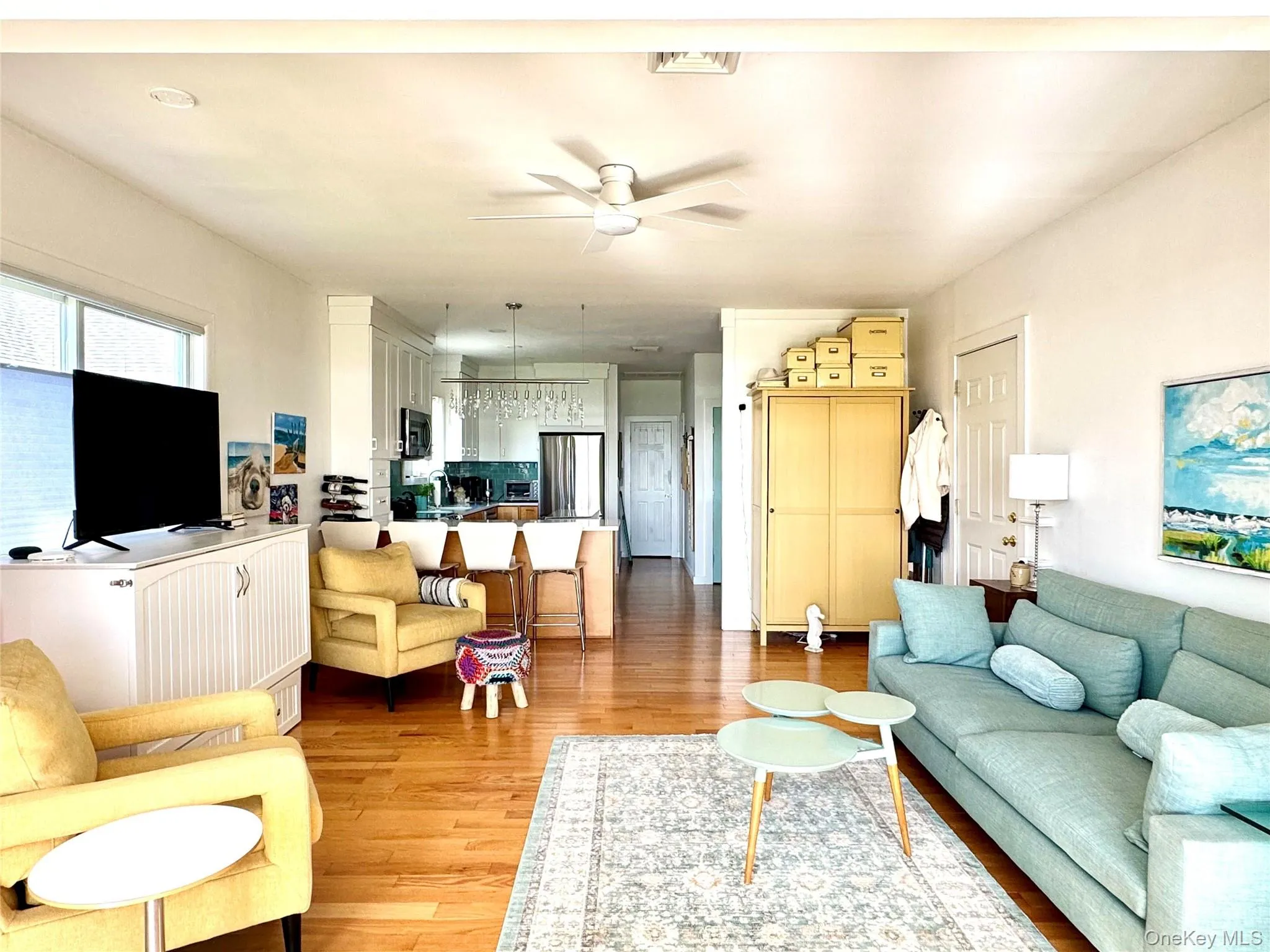 Living room with light wood-style floors and a ceiling fan Living room with light wood-style floors and a ceiling fan