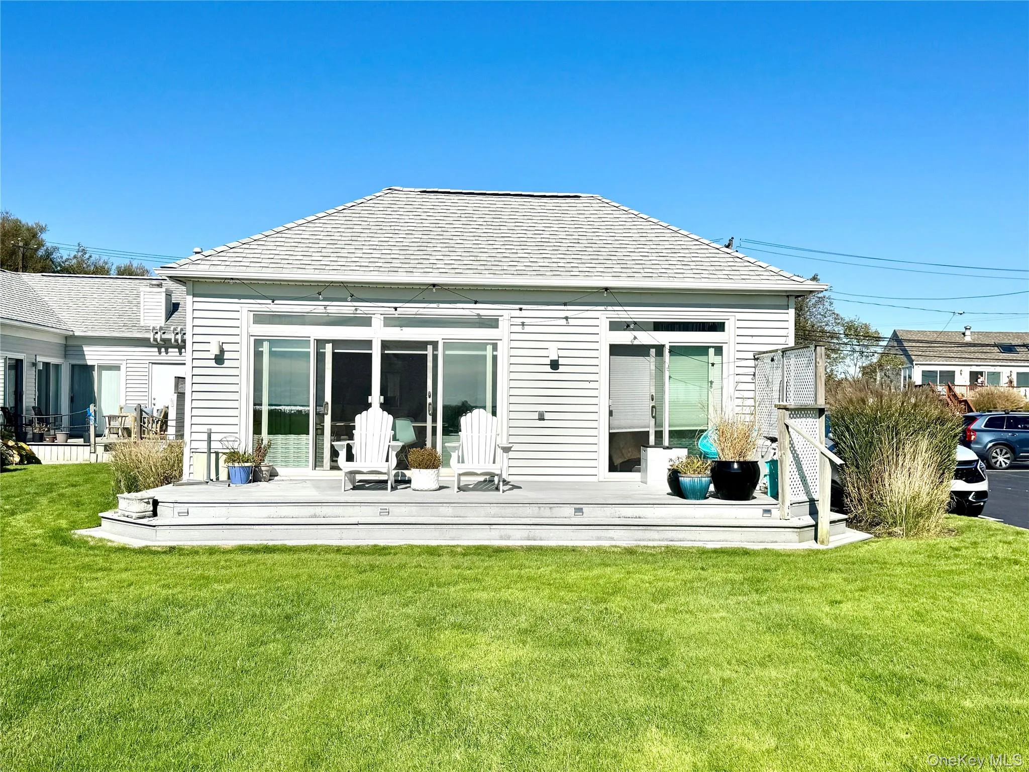 Back of property with a yard, a deck, and roof with shingles Back of property with a yard, a deck, and roof with shingles