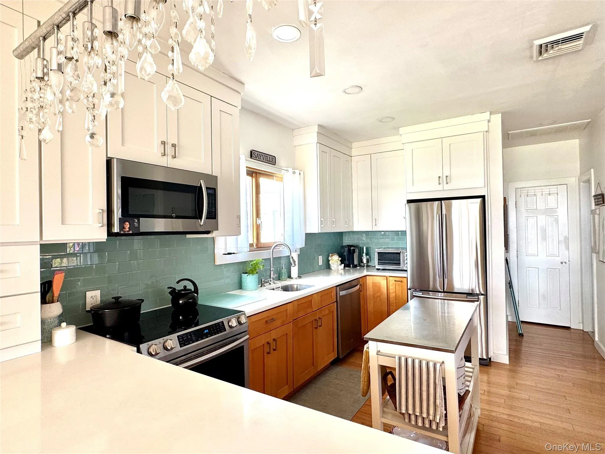 Kitchen with light countertops, appliances with stainless steel finishes, recessed lighting, backsplash, and light wood-type flooring Kitchen with light countertops, appliances with stainless steel finishes, recessed lighting, backsplash, and light wood-type flooring