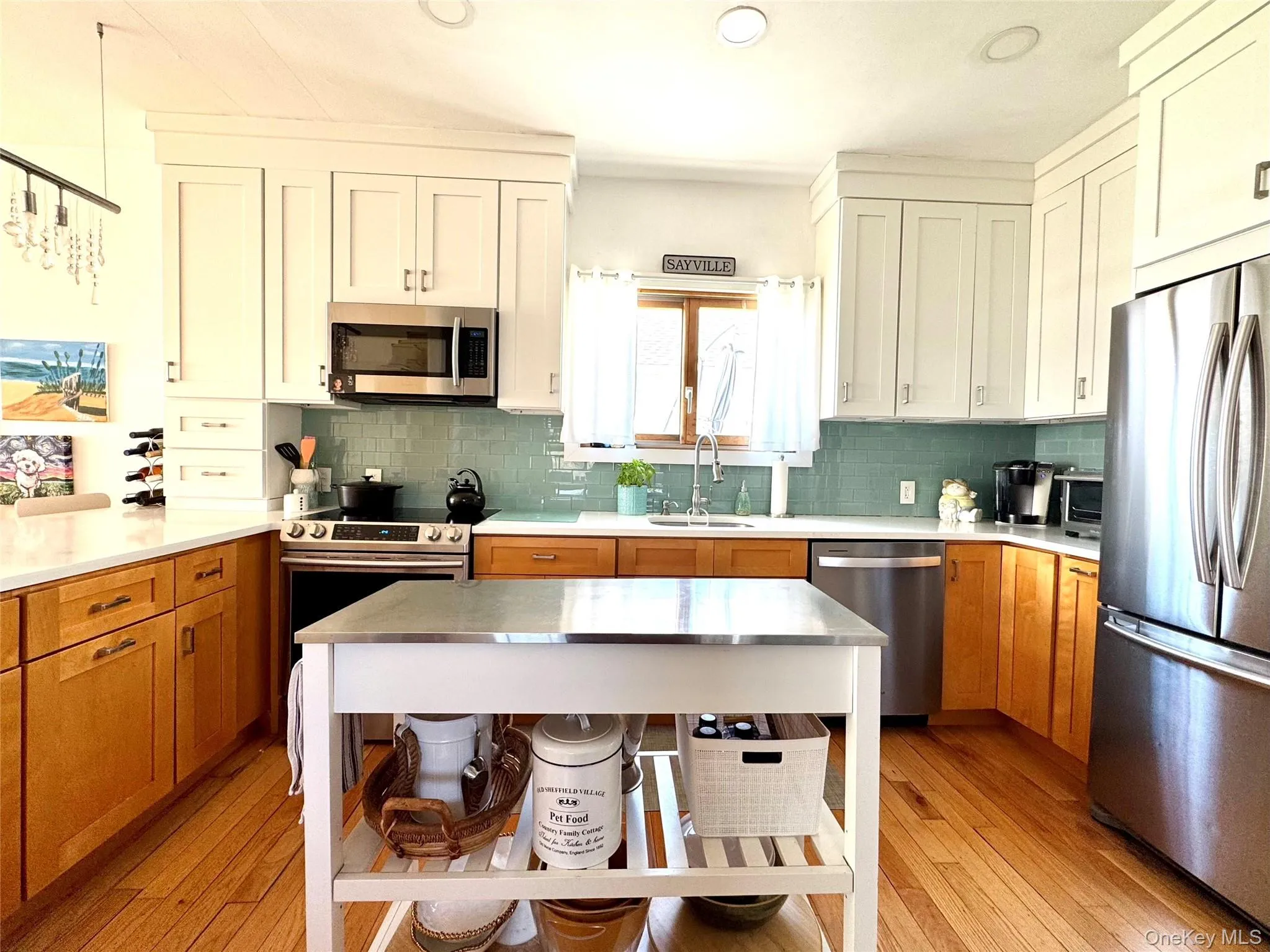 Kitchen with stainless steel appliances, light wood-style floors, brown cabinets, recessed lighting, and white cabinets Kitchen with stainless steel appliances, light wood-style floors, brown cabinets, recessed lighting, and white cabinets