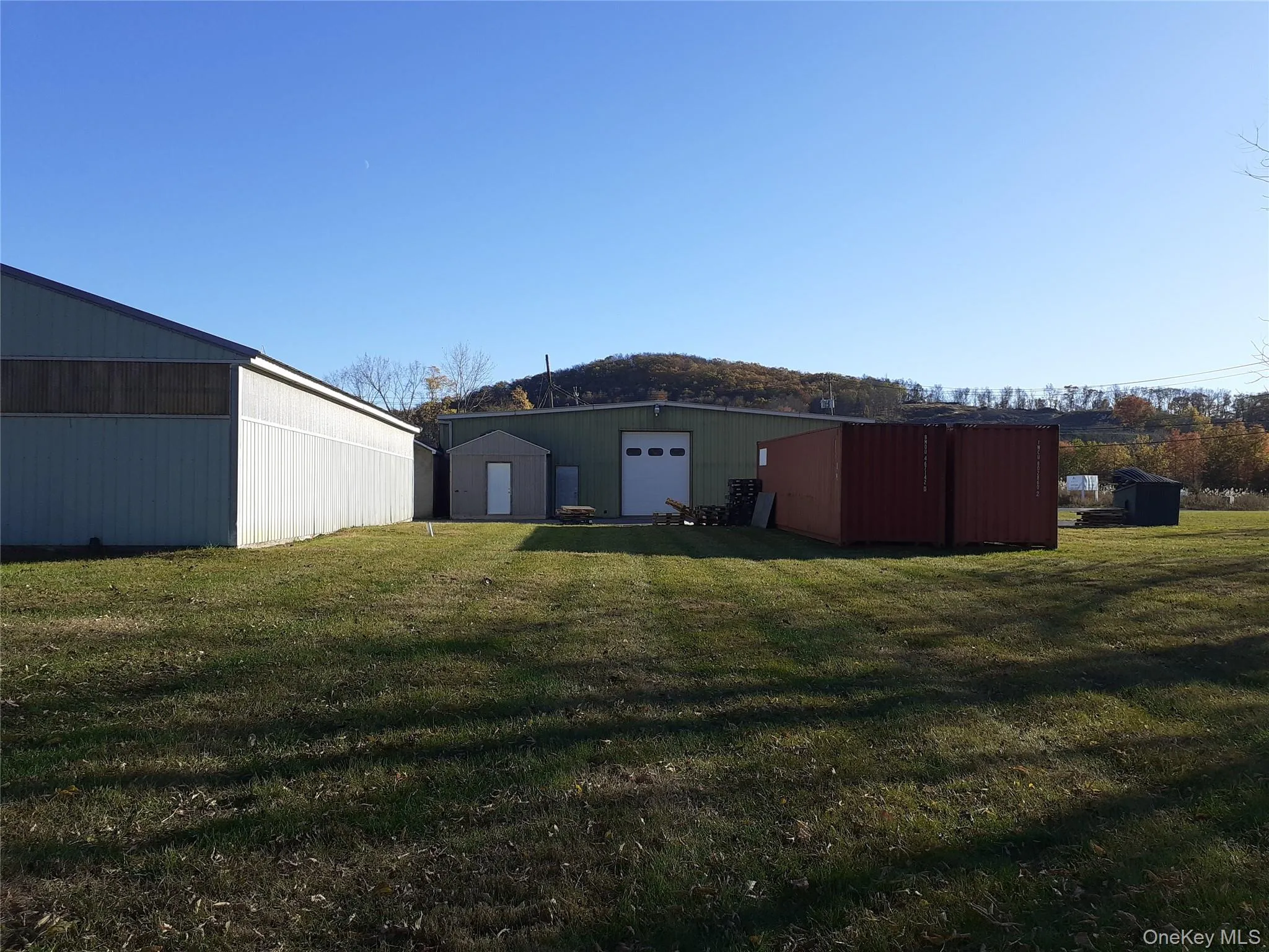 Back of property with an outbuilding, an outdoor structure, and a lawn Back of property with an outbuilding, an outdoor structure, and a lawn