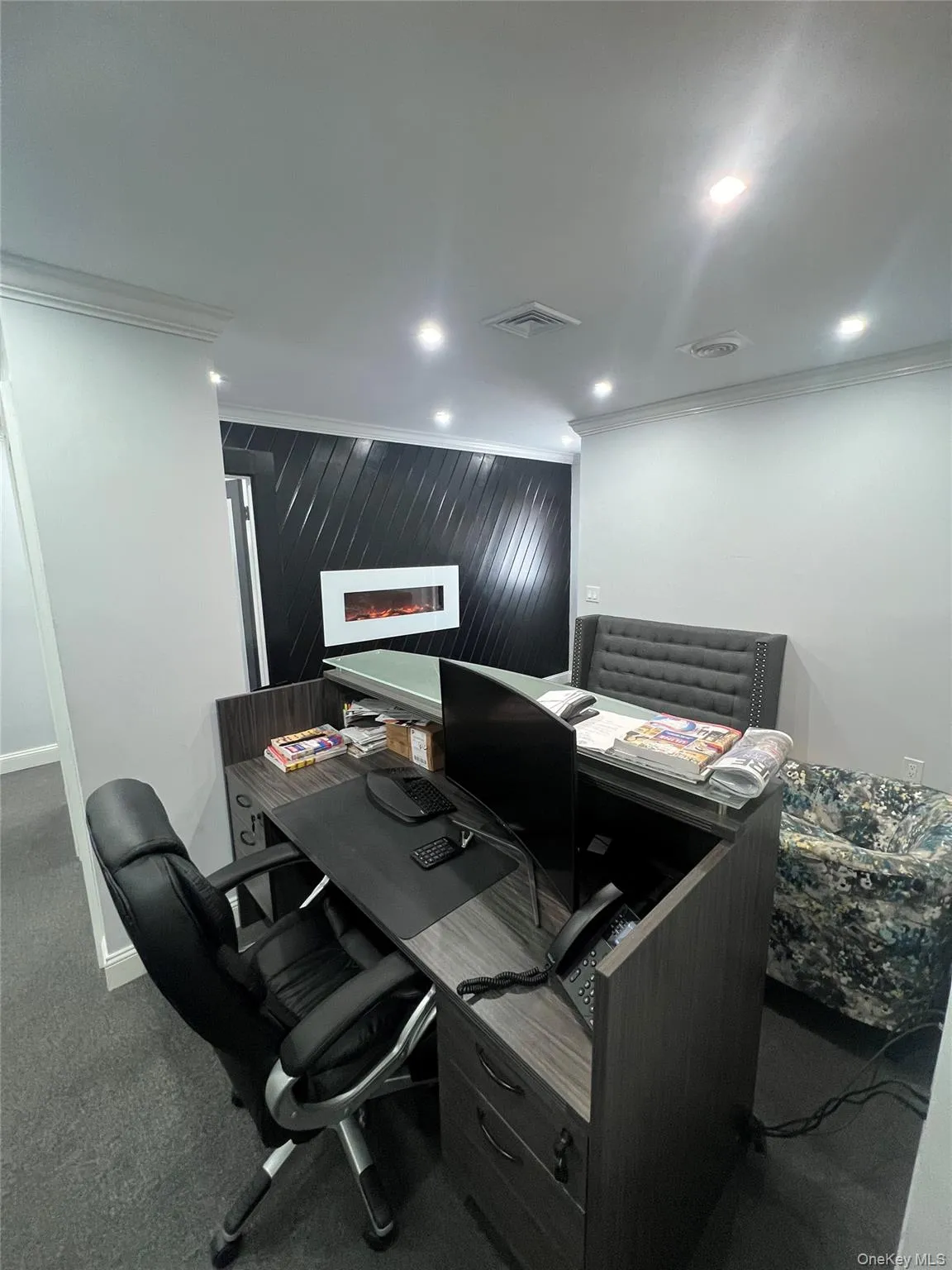 Office space with crown molding, recessed lighting, and dark colored carpet Office space with crown molding, recessed lighting, and dark colored carpet