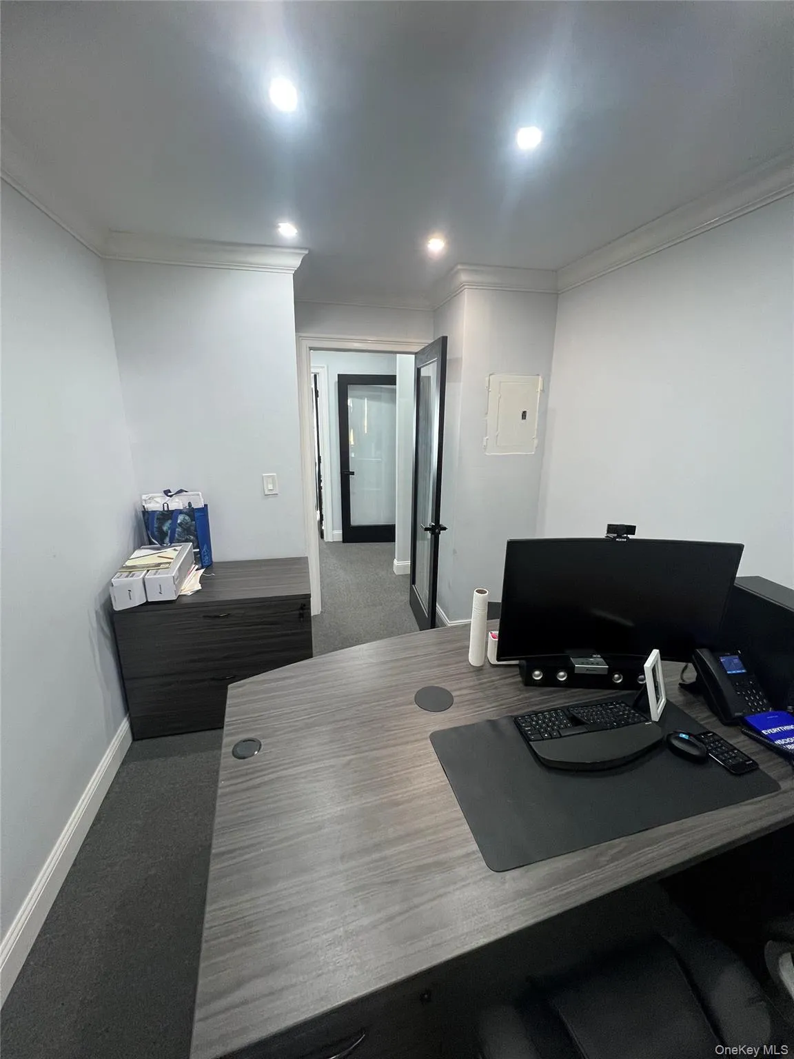 Office area featuring dark colored carpet, ornamental molding, recessed lighting, and electric panel Office area featuring dark colored carpet, ornamental molding, recessed lighting, and electric panel