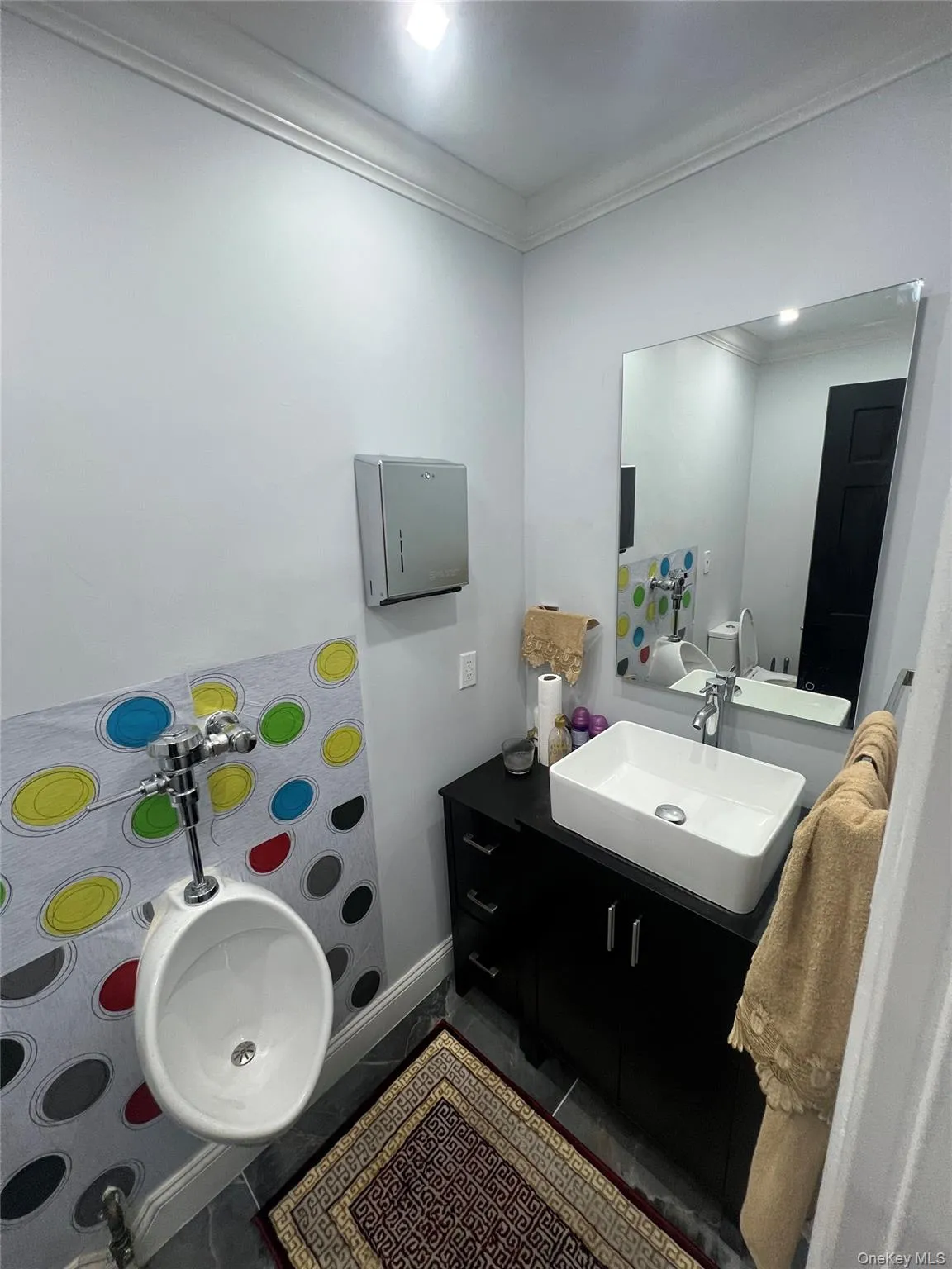 Bathroom featuring crown molding, vanity, and dark tile patterned flooring Bathroom featuring crown molding, vanity, and dark tile patterned flooring