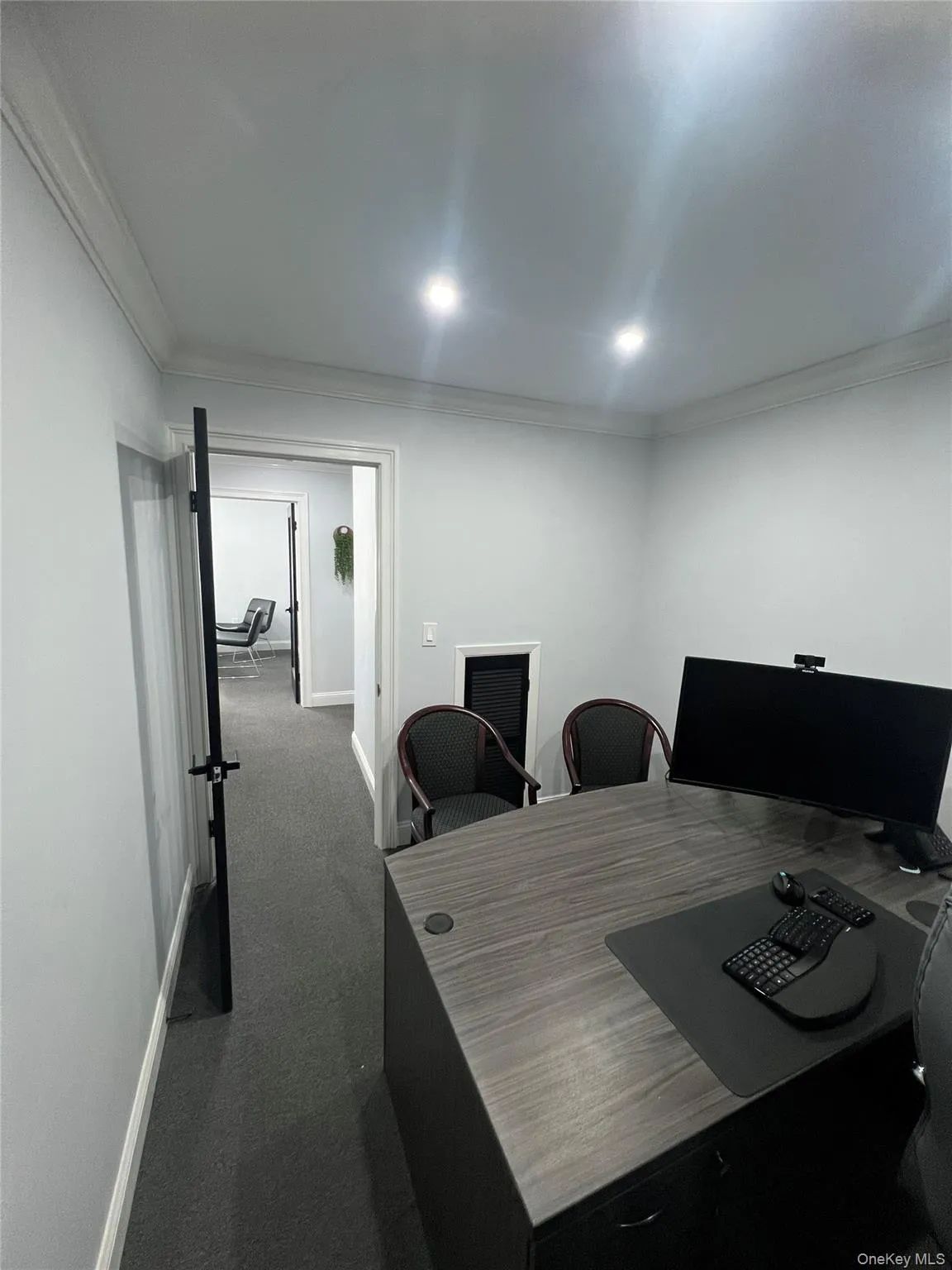 Office area featuring ornamental molding and dark carpet Office area featuring ornamental molding and dark carpet