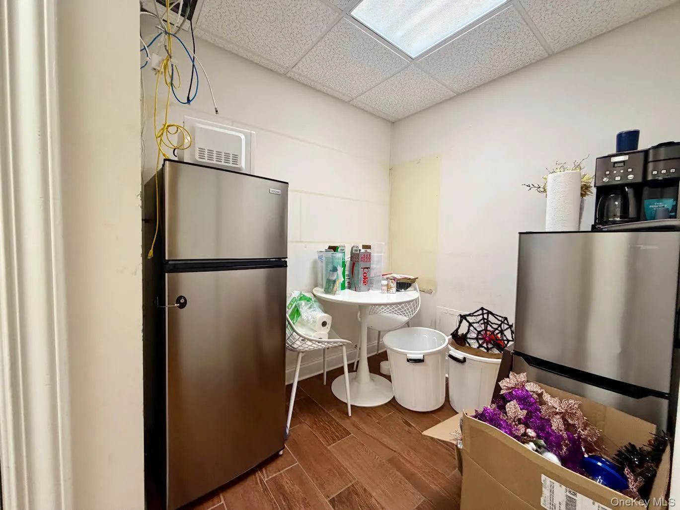 Kitchen with a paneled ceiling, dark wood-style flooring, and freestanding refrigerator Kitchen with a paneled ceiling, dark wood-style flooring, and freestanding refrigerator