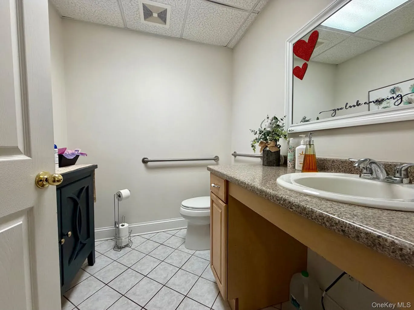 Bathroom with light tile patterned floors, a paneled ceiling, and vanity Bathroom with light tile patterned floors, a paneled ceiling, and vanity