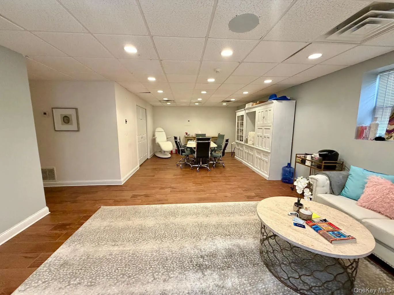 Reception room featuring a paneled ceiling, recessed lighting, and light wood-style floors Reception room featuring a paneled ceiling, recessed lighting, and light wood-style floors