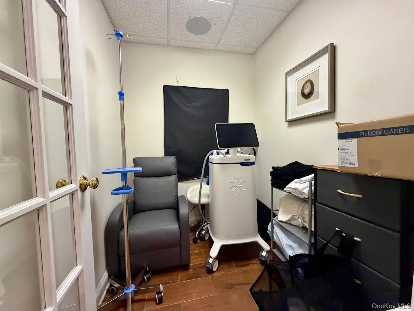 Office space featuring a drop ceiling and dark wood finished floors Office space featuring a drop ceiling and dark wood finished floors