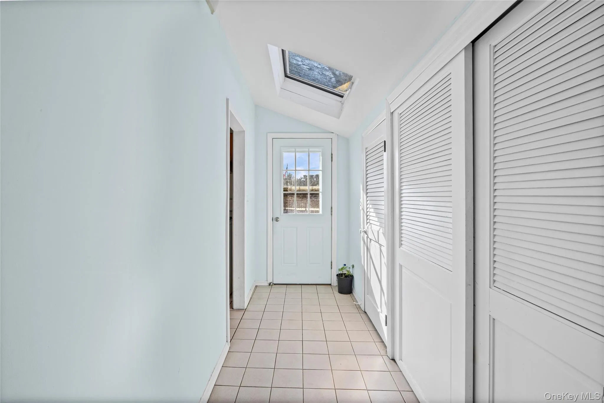 Corridor of closets featuring a skylight, vaulted ceiling Corridor of closets featuring a skylight, vaulted ceiling