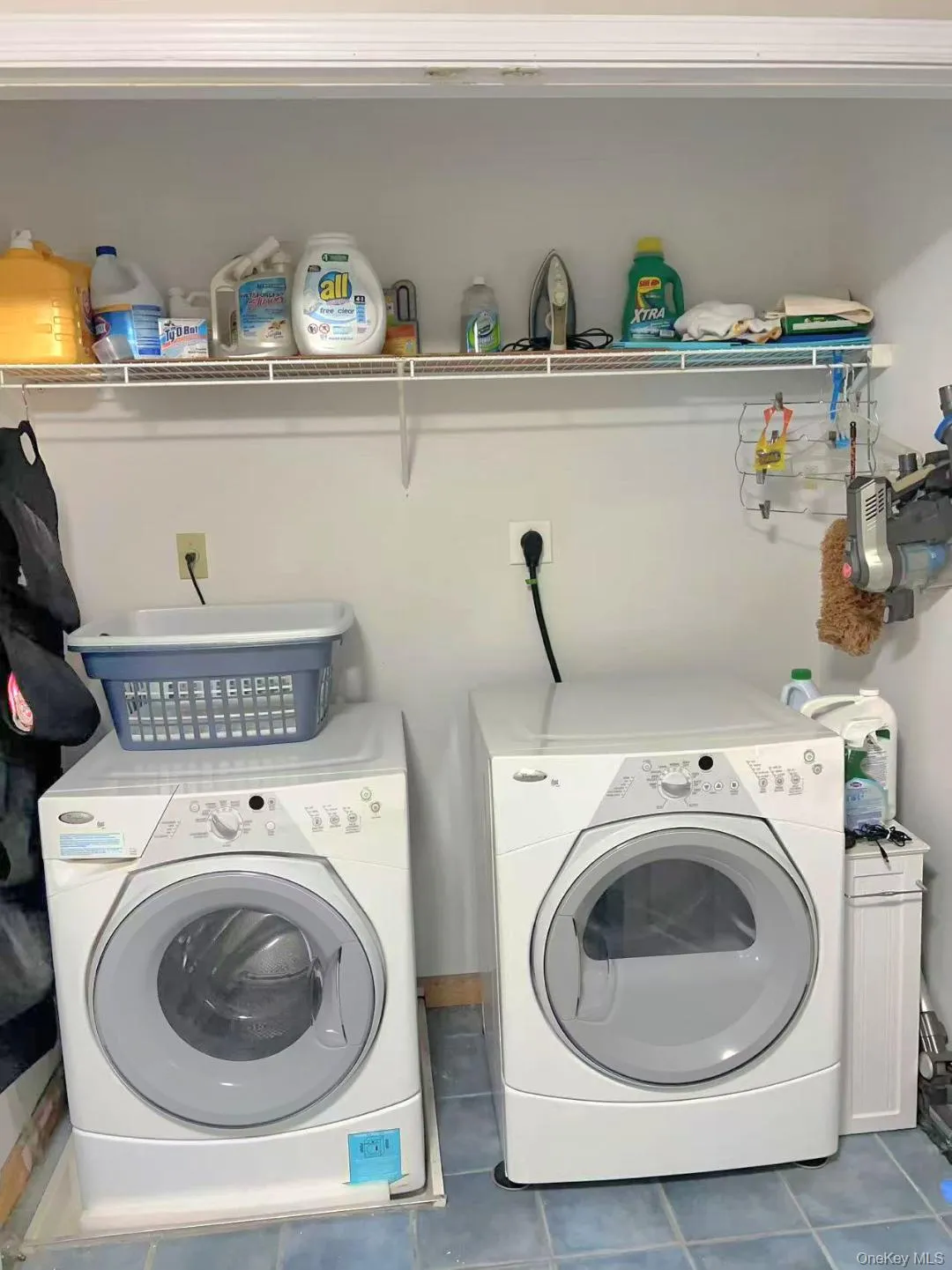 Washroom featuring dark tile patterned flooring and washer and clothes dryer Washroom featuring dark tile patterned flooring and washer and clothes dryer