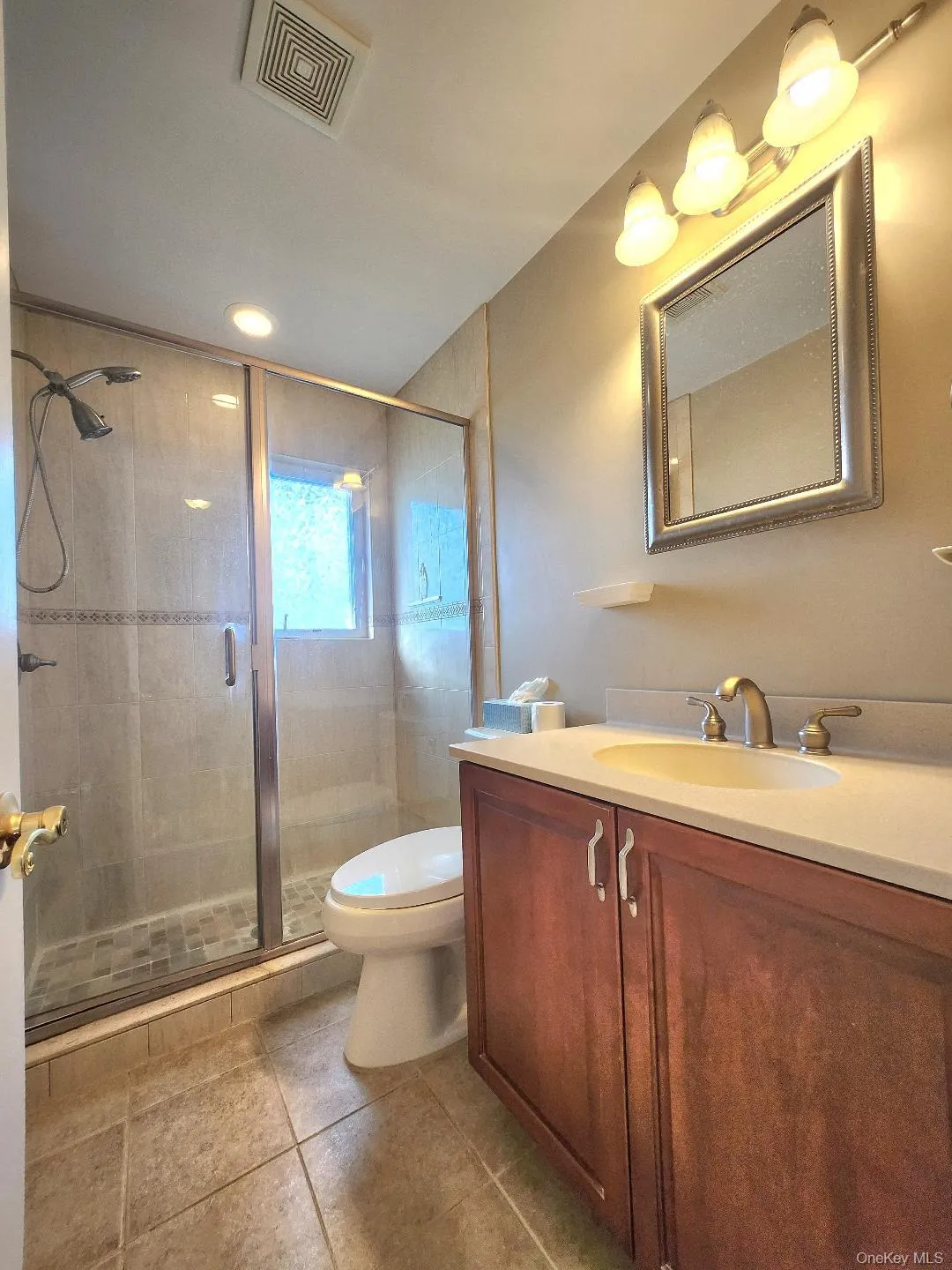 Full bath with vanity, a stall shower, light tile patterned flooring, and recessed lighting Full bath with vanity, a stall shower, light tile patterned flooring, and recessed lighting