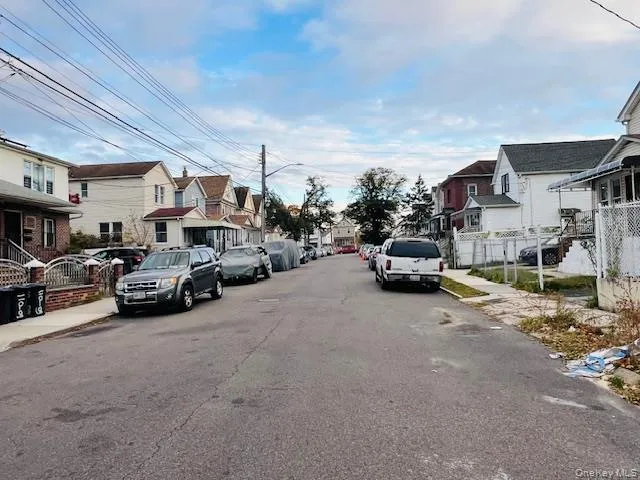 View of asphalt street with sidewalks, a residential view, street lights, and curbs View of asphalt street with sidewalks, a residential view, street lights, and curbs