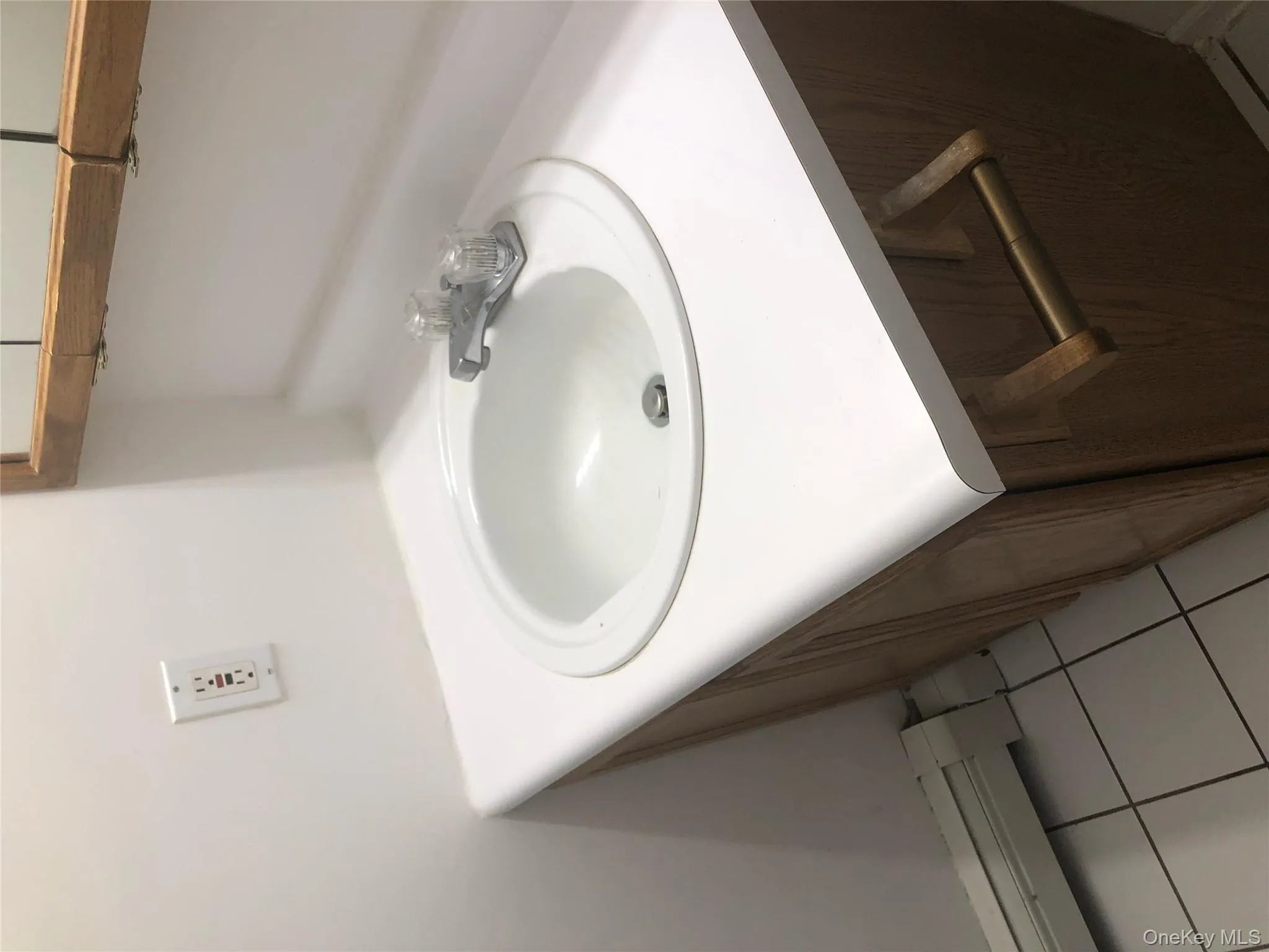 Bathroom with vanity, light tile patterned floors, and a baseboard heating unit Bathroom with vanity, light tile patterned floors, and a baseboard heating unit