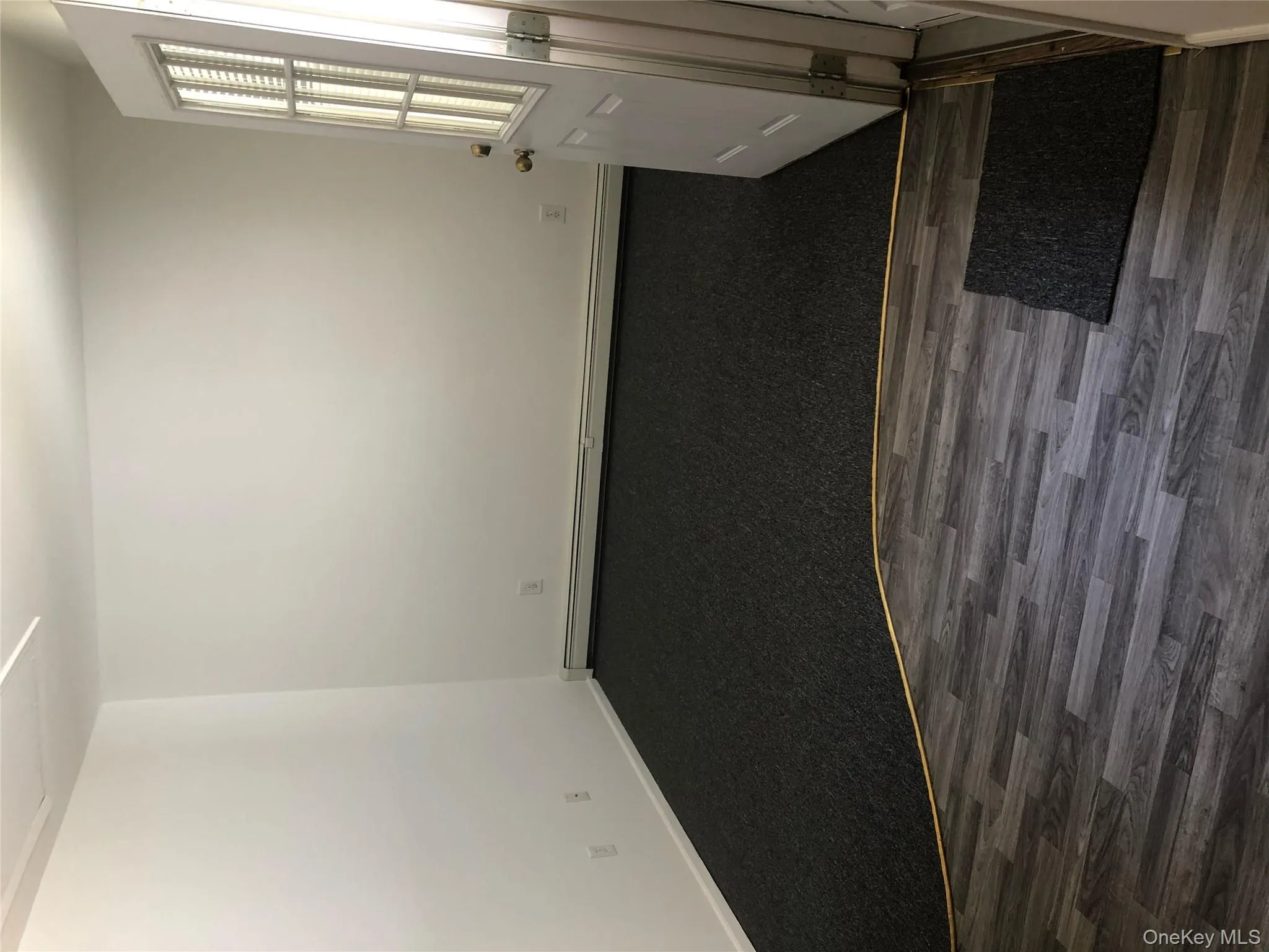 Empty room featuring a baseboard heating unit and dark wood-style floors Empty room featuring a baseboard heating unit and dark wood-style floors
