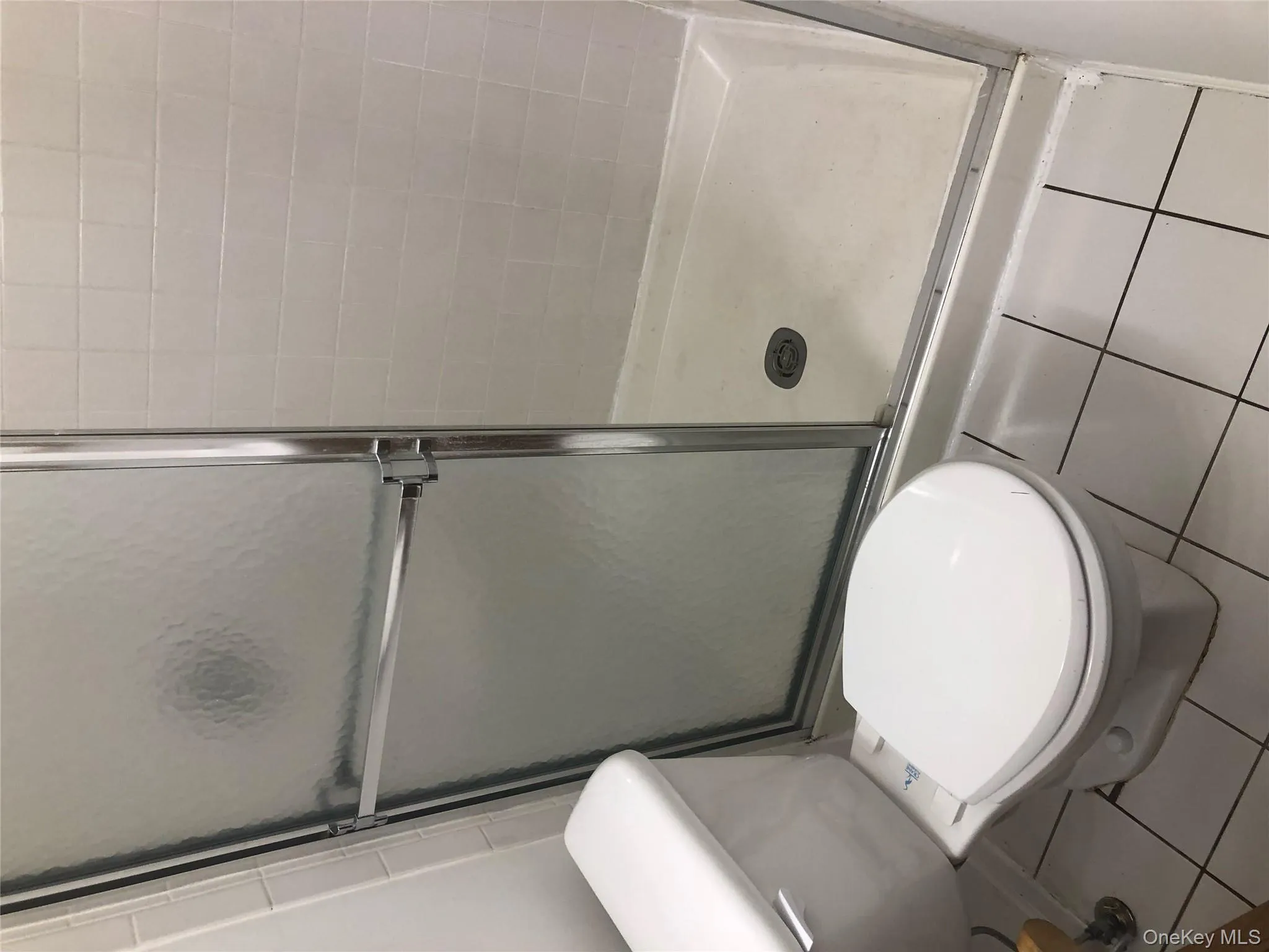 Bathroom with tile patterned flooring and a shower stall Bathroom with tile patterned flooring and a shower stall