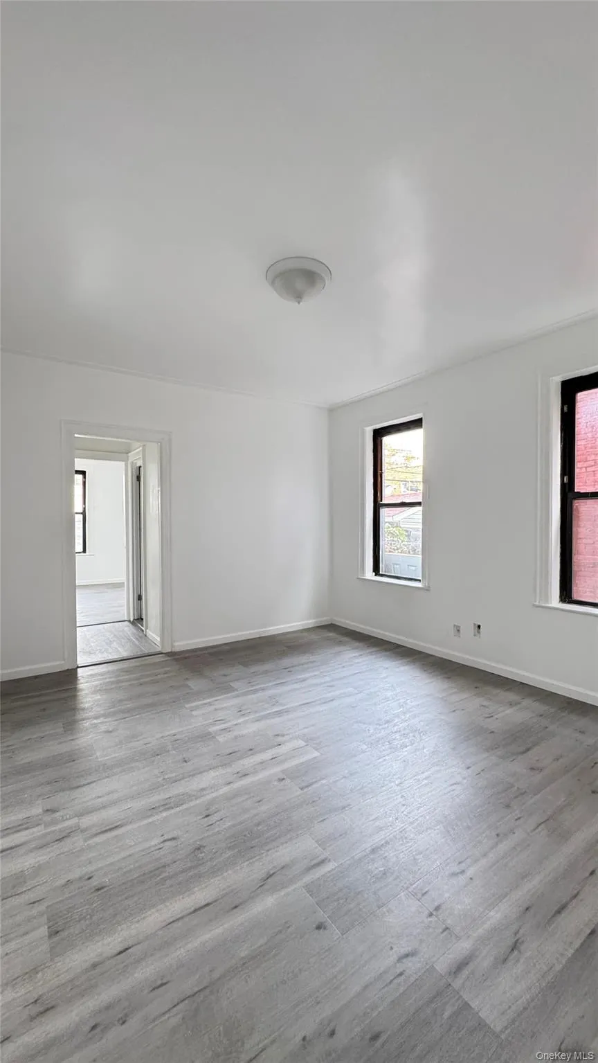 Spare room featuring light wood-style floors and baseboards Spare room featuring light wood-style floors and baseboards