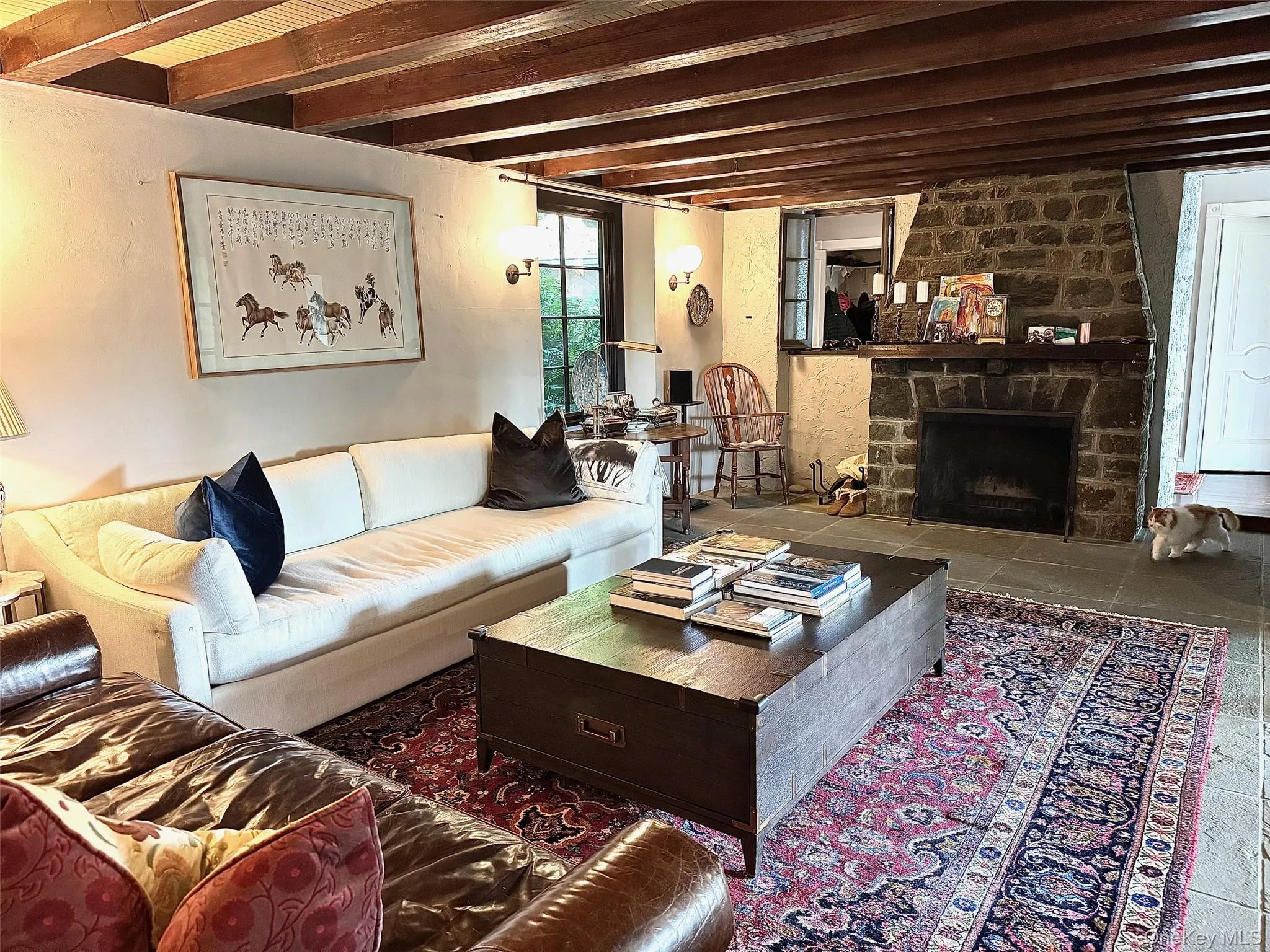 Living room featuring beam ceiling and a fireplace Living room featuring beam ceiling and a fireplace