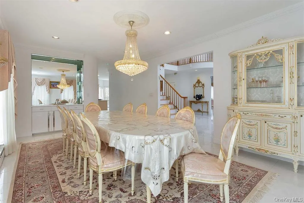 Dining area featuring light tile patterned floors, recessed lighting, ornamental molding, stairs, and a chandelier Dining area featuring light tile patterned floors, recessed lighting, ornamental molding, stairs, and a chandelier