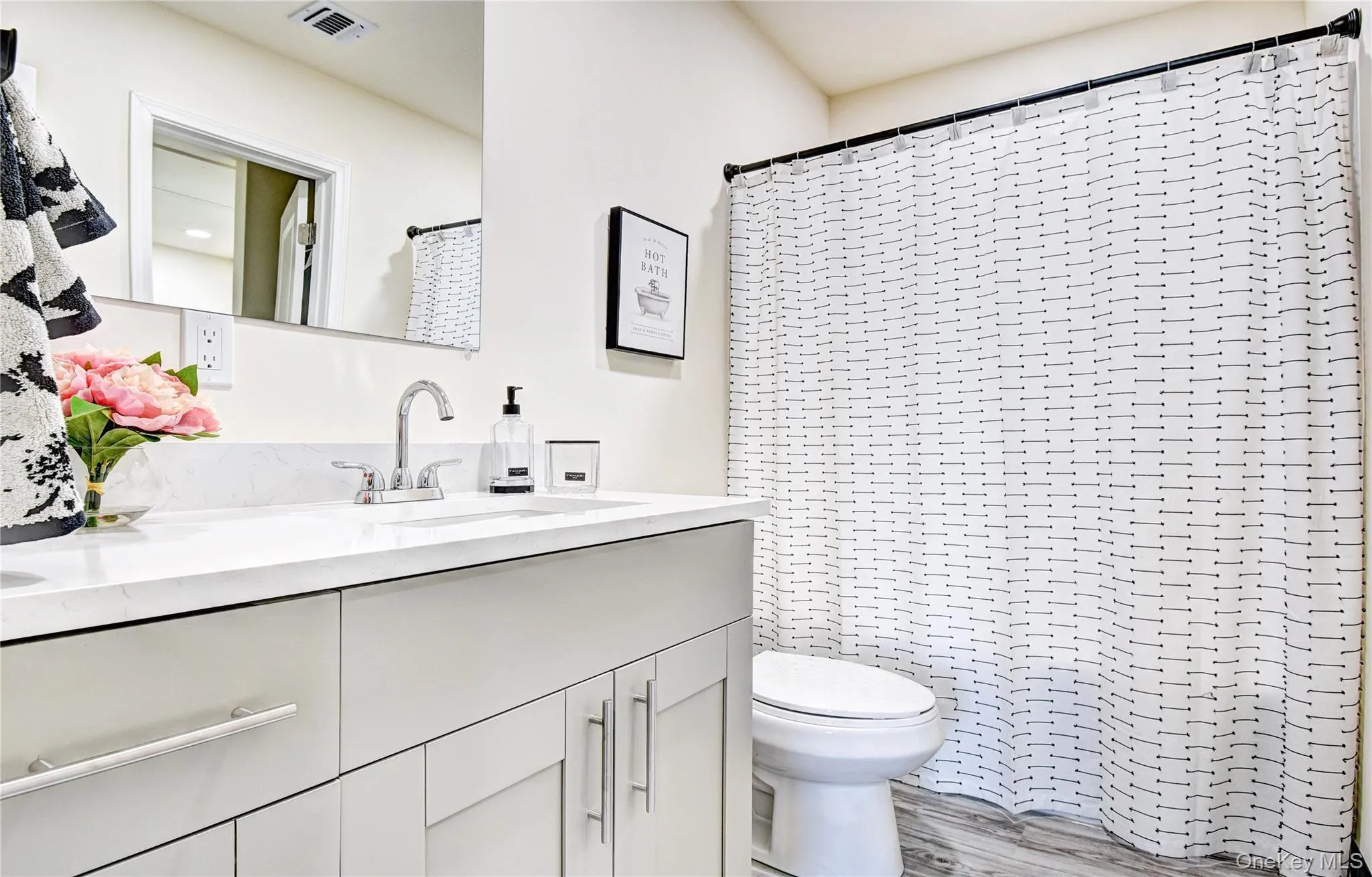 Bathroom featuring toilet, wood-type flooring, vanity, and curtained shower Bathroom featuring toilet, wood-type flooring, vanity, and curtained shower