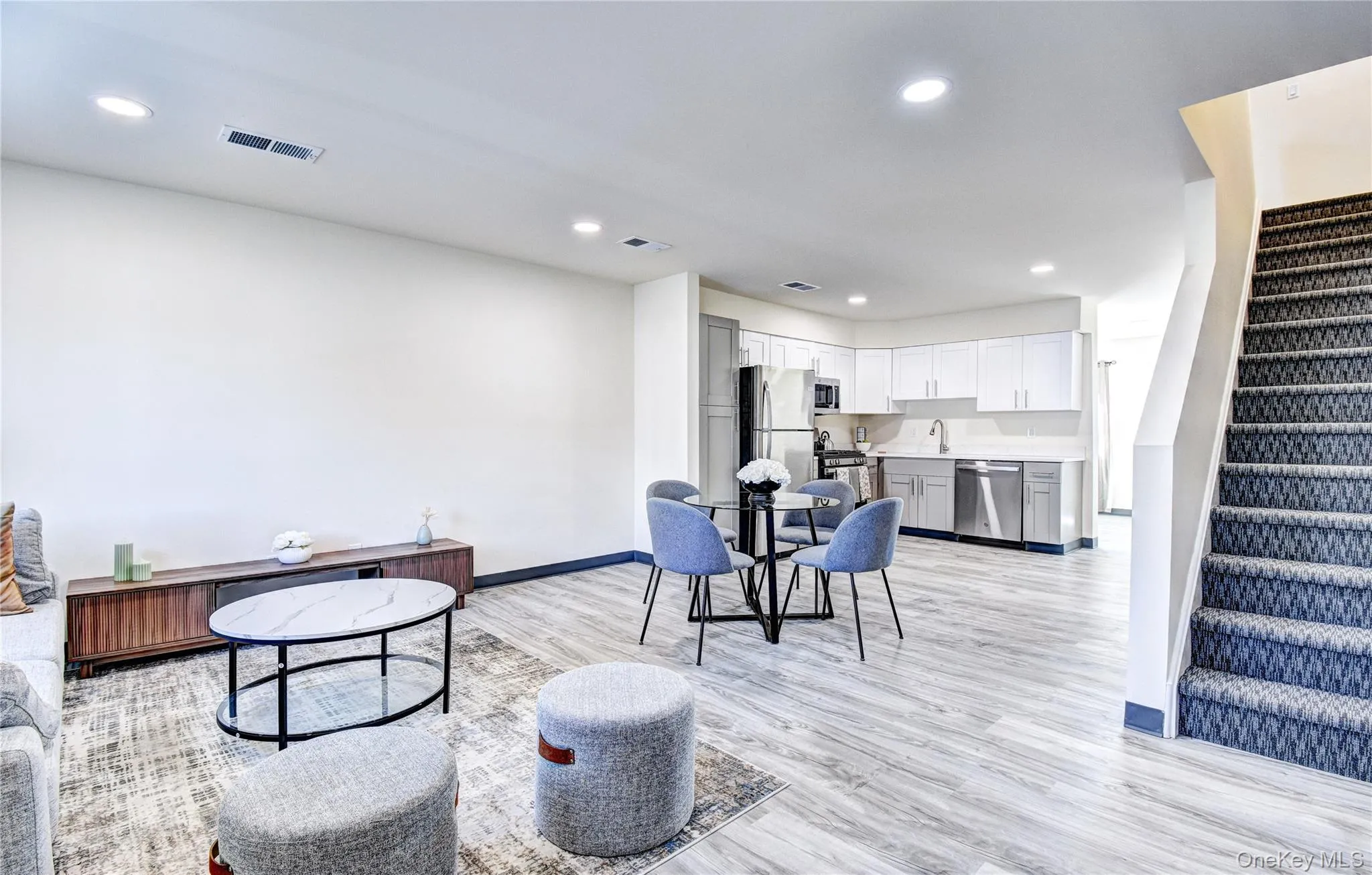 Living room featuring light hardwood / wood-style flooring and sink Living room featuring light hardwood / wood-style flooring and sink