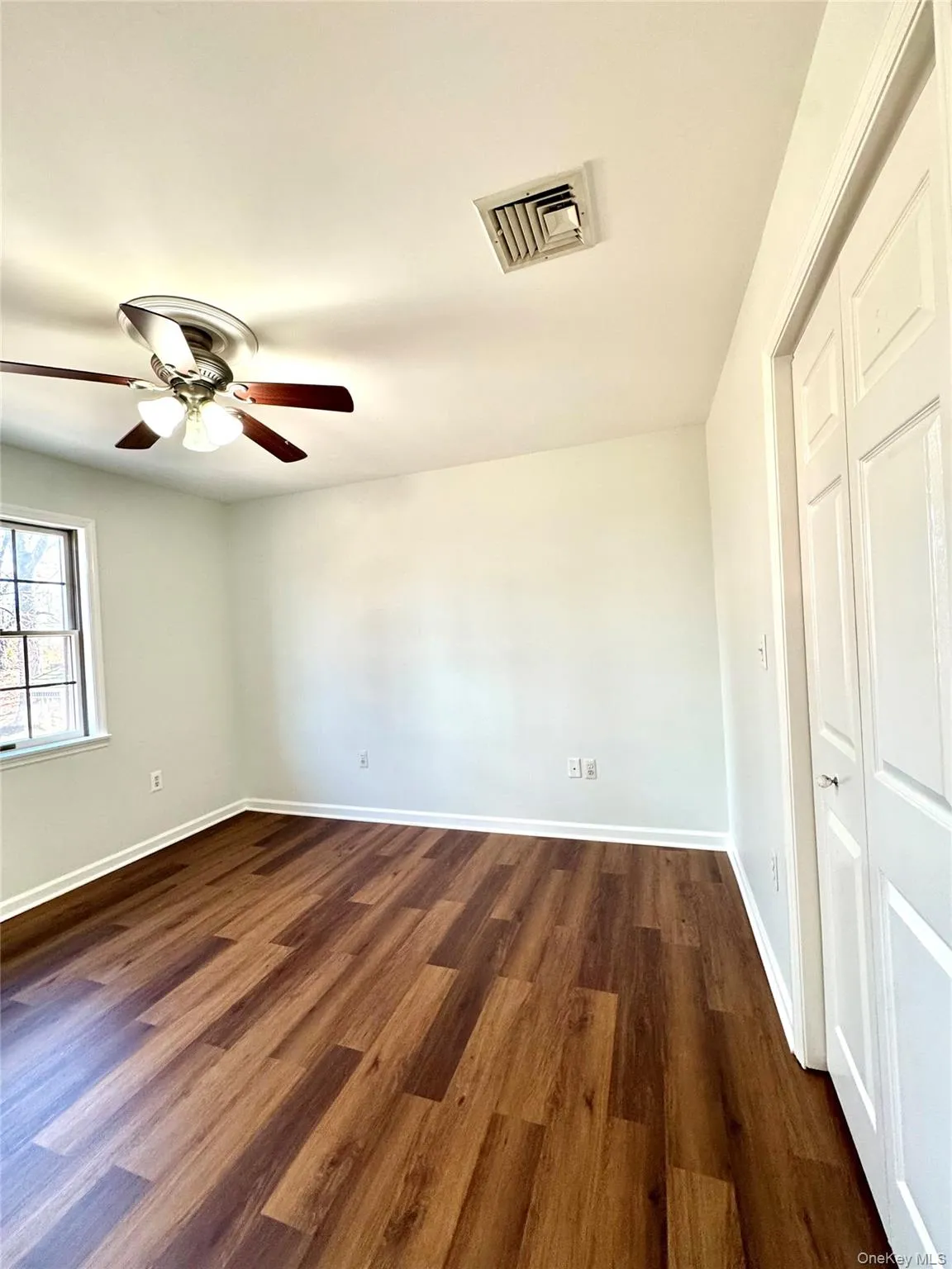 Unfurnished bedroom with dark wood finished floors and ceiling fan Unfurnished bedroom with dark wood finished floors and ceiling fan