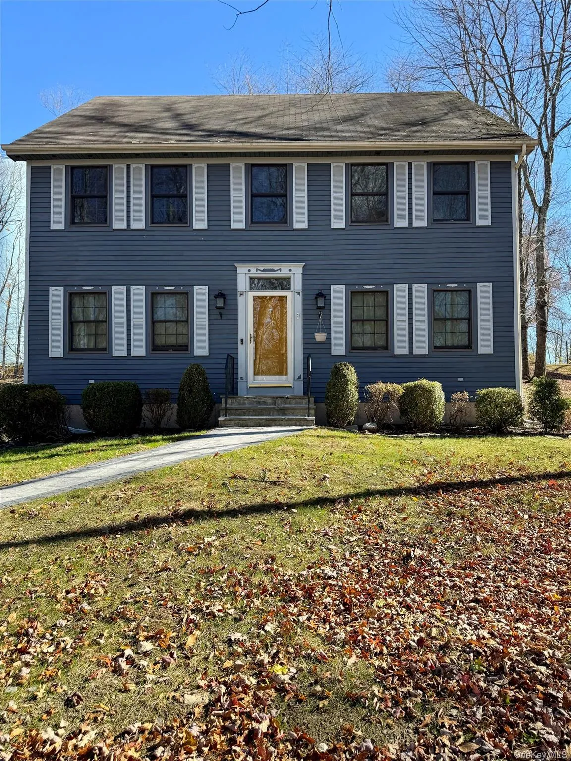 Colonial-style house featuring a front yard Colonial-style house featuring a front yard