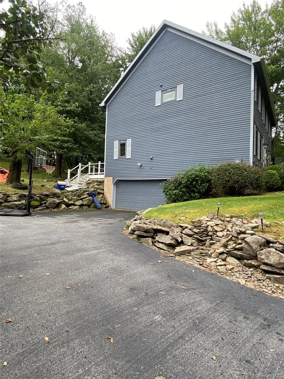 View of side of home featuring asphalt driveway and a garage View of side of home featuring asphalt driveway and a garage