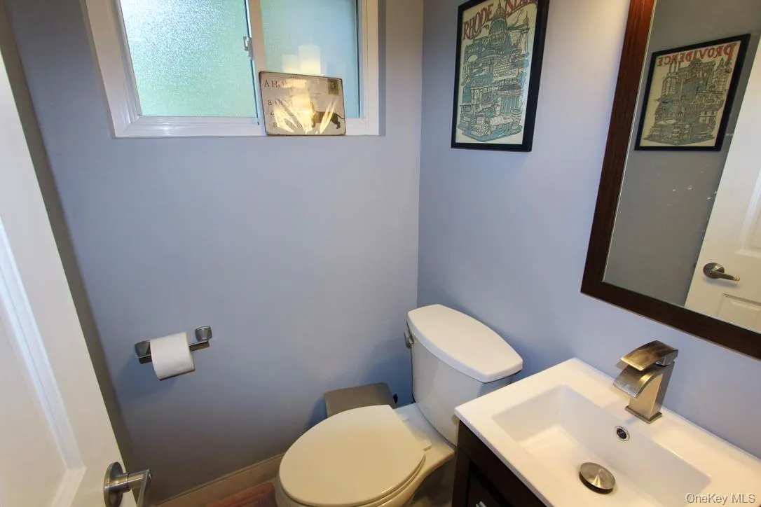 Half bathroom featuring vanity and toilet Half bathroom featuring vanity and toilet