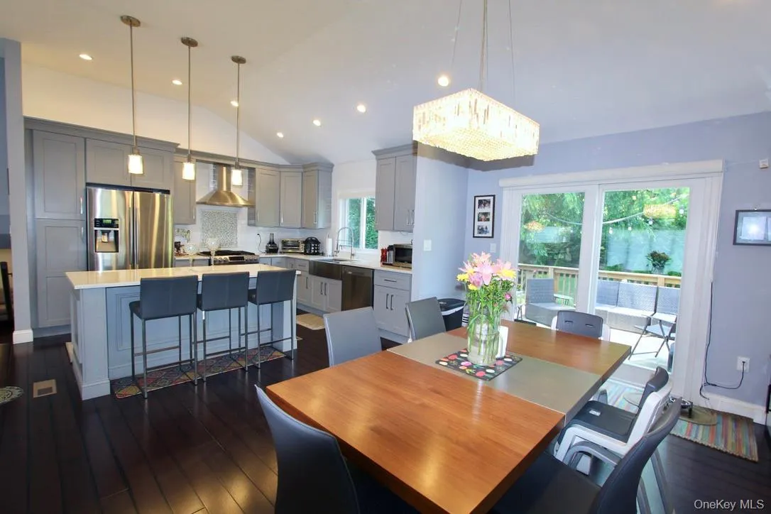 Dining room with vaulted ceiling, dark wood-style floors, and recessed lighting Dining room with vaulted ceiling, dark wood-style floors, and recessed lighting