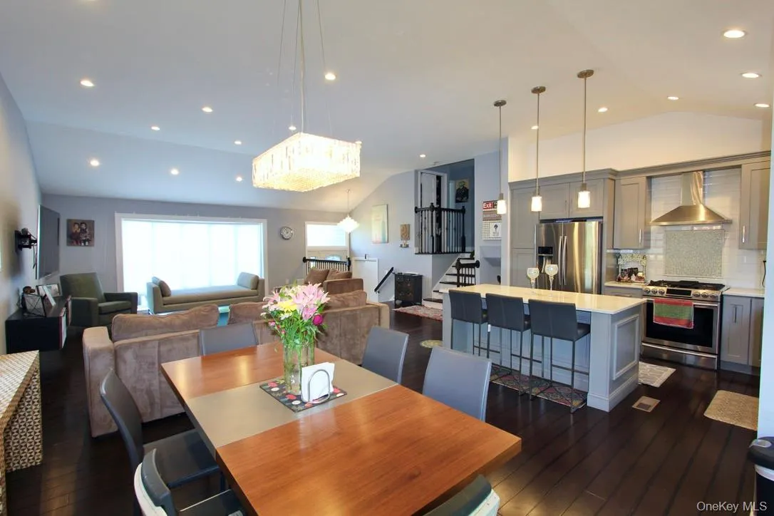 Dining area featuring lofted ceiling, stairway, dark wood finished floors, and recessed lighting Dining area featuring lofted ceiling, stairway, dark wood finished floors, and recessed lighting