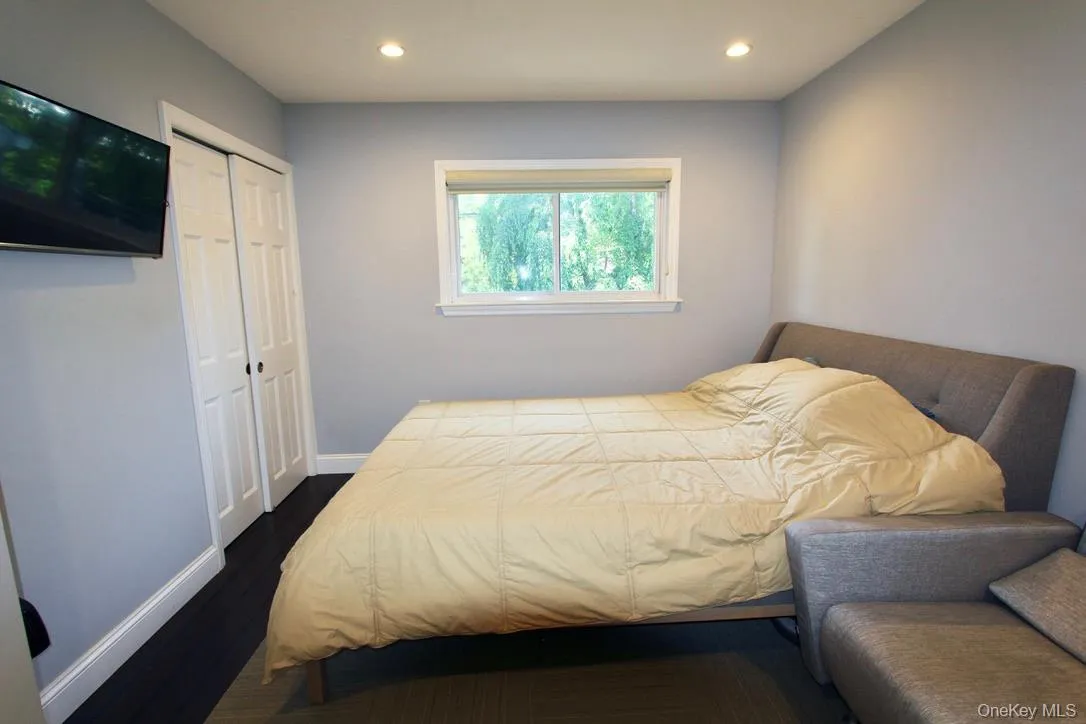 Bedroom featuring dark wood-style flooring, recessed lighting, and a closet Bedroom featuring dark wood-style flooring, recessed lighting, and a closet