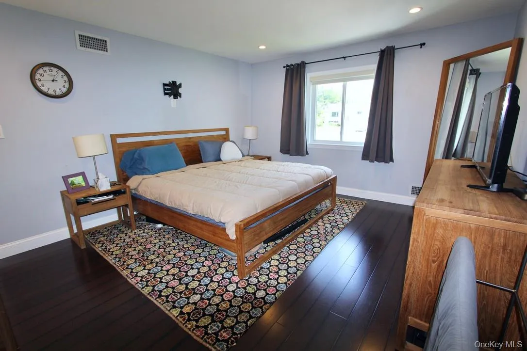 Bedroom featuring dark wood-type flooring and recessed lighting Bedroom featuring dark wood-type flooring and recessed lighting