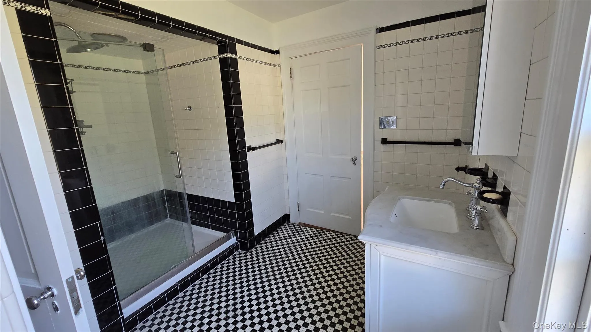 Bathroom with vanity, a stall shower, and tile walls Bathroom with vanity, a stall shower, and tile walls