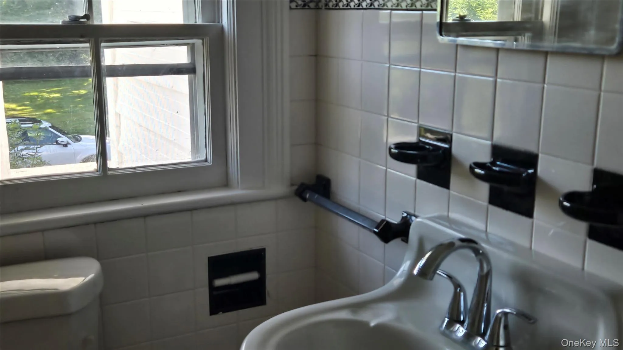 Bathroom featuring tile walls and a sink Bathroom featuring tile walls and a sink