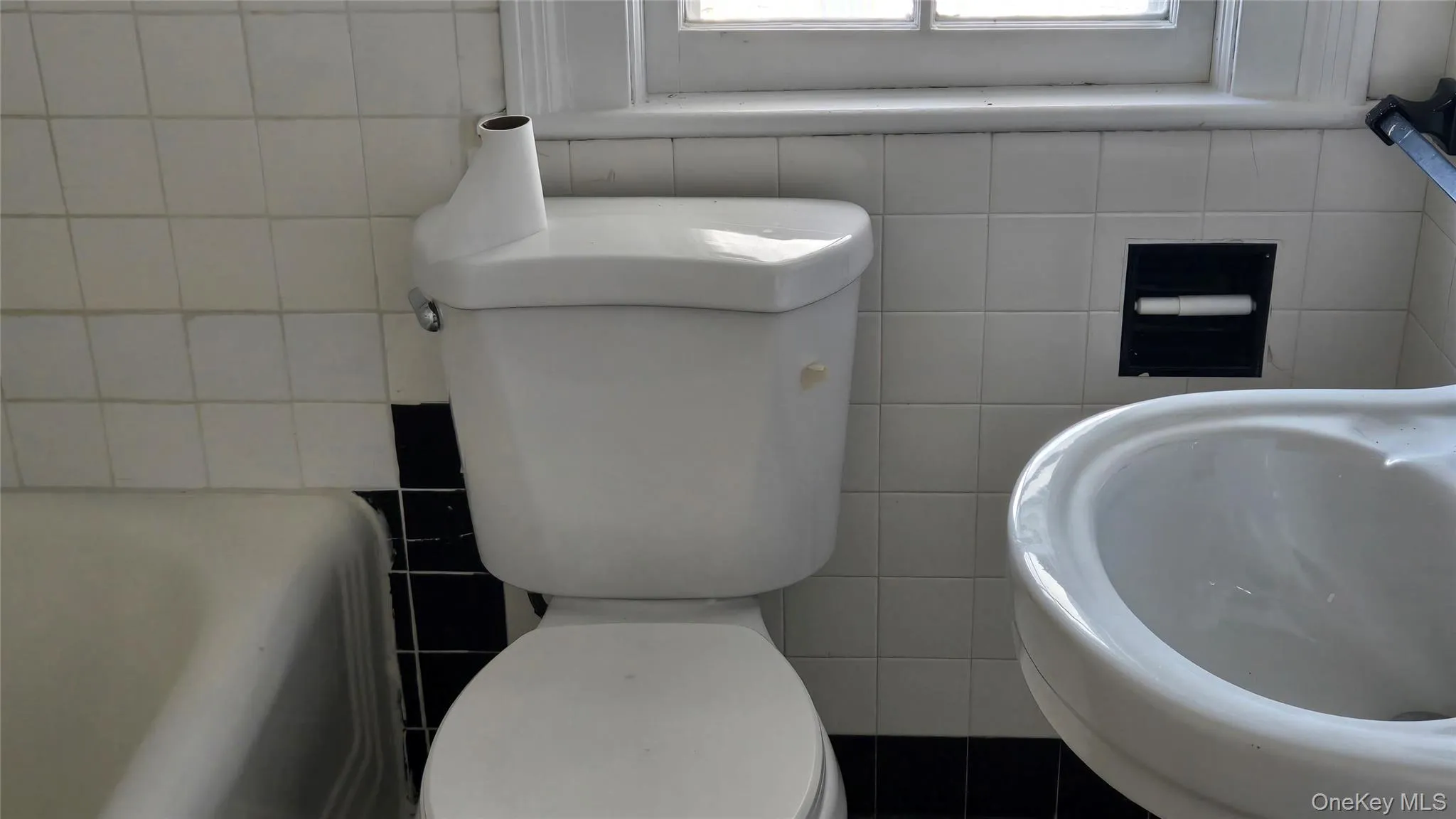 Bathroom with tile walls, a tub to relax in, and healthy amount of natural light Bathroom with tile walls, a tub to relax in, and healthy amount of natural light