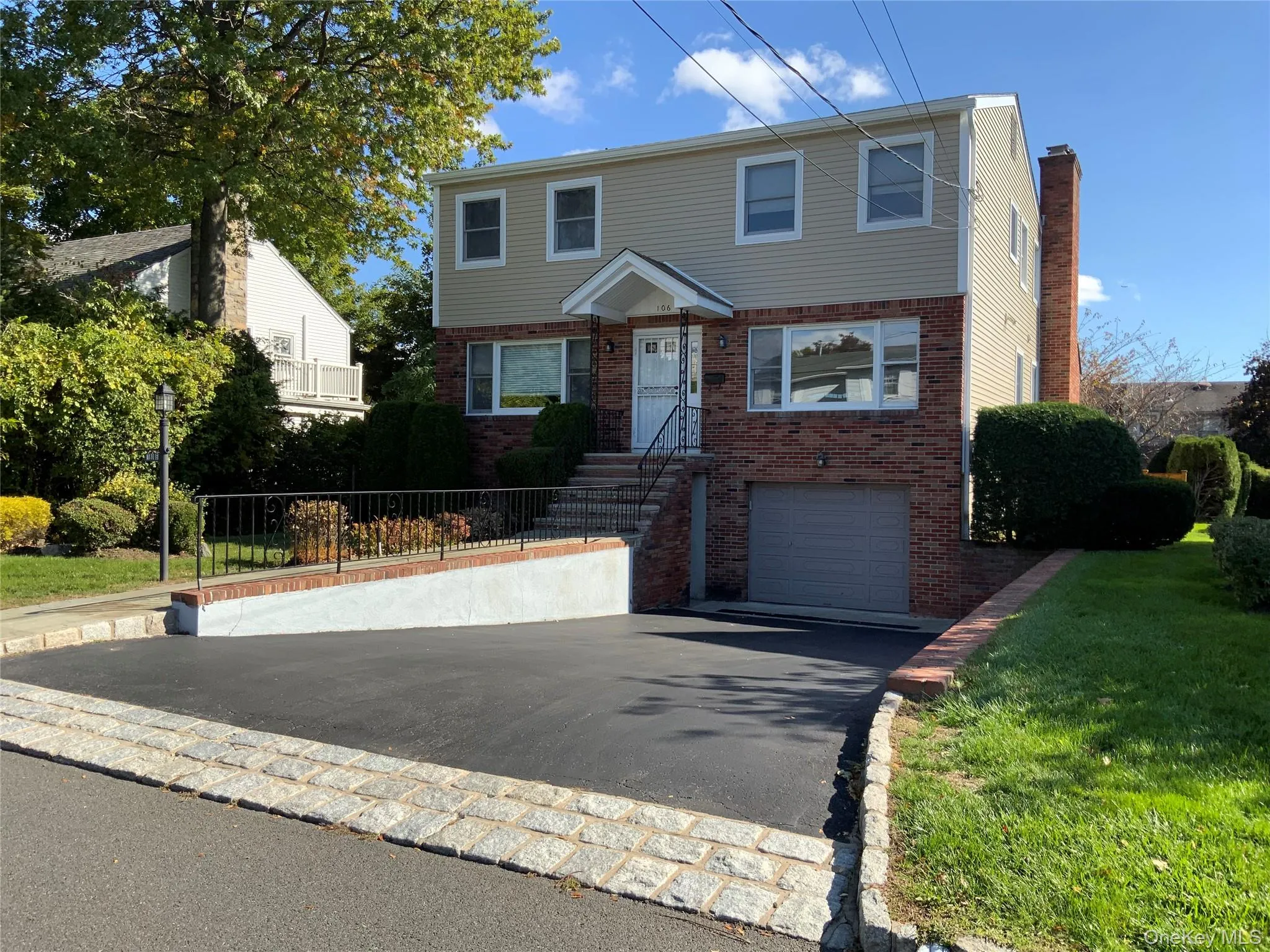 Colonial inspired home featuring driveway, brick siding, and a garage Colonial inspired home featuring driveway, brick siding, and a garage
