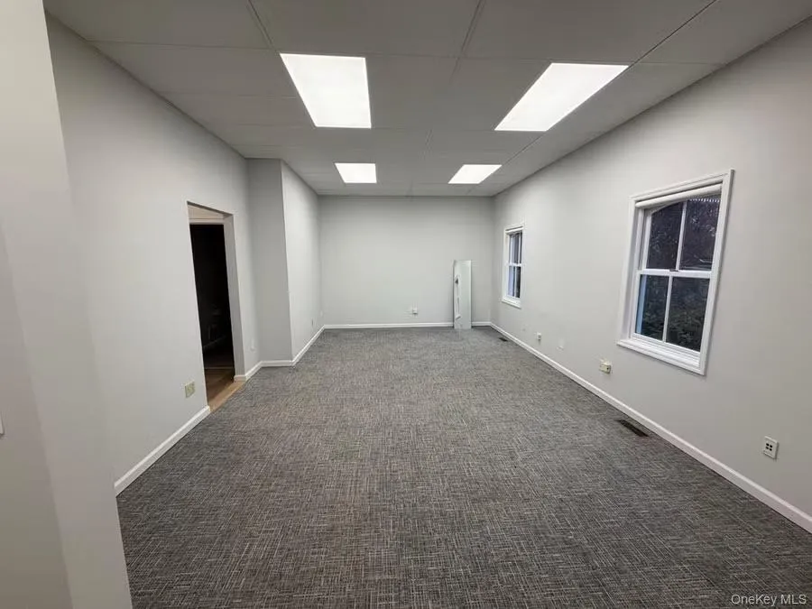 Spare room with dark colored carpet and a paneled ceiling Spare room with dark colored carpet and a paneled ceiling