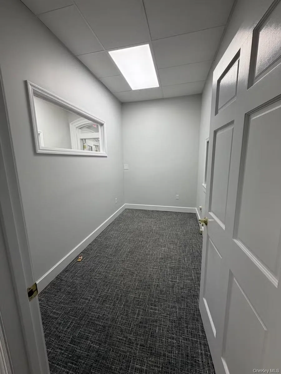 Unfurnished room with dark carpet and a paneled ceiling Unfurnished room with dark carpet and a paneled ceiling