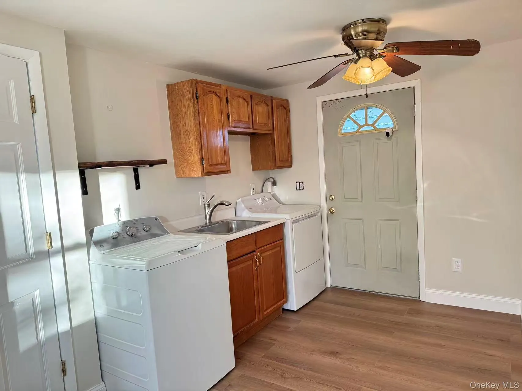 Laundry room featuring dark wood-style floors, cabinet space, washing machine and dryer, and a ceiling fan Laundry room featuring dark wood-style floors, cabinet space, washing machine and dryer, and a ceiling fan