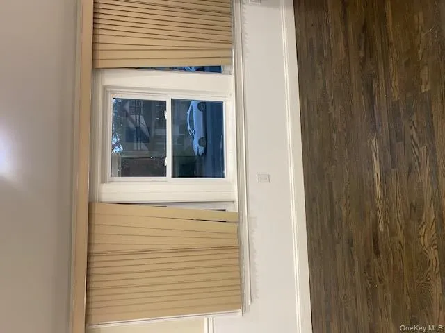 Spare room featuring dark wood-type flooring and baseboards Spare room featuring dark wood-type flooring and baseboards