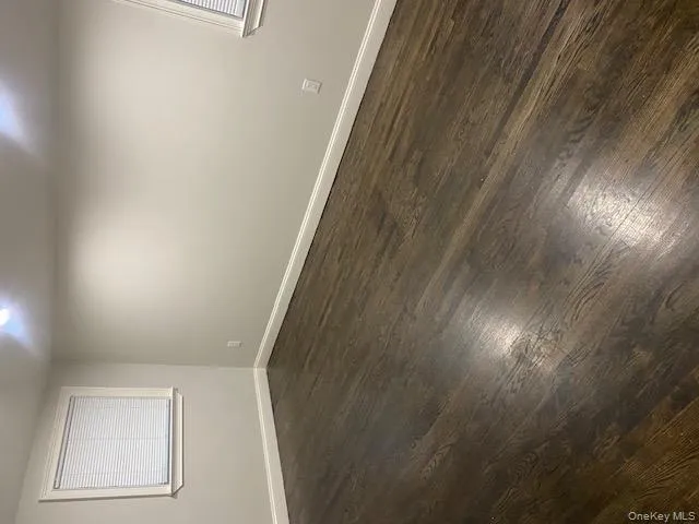 Empty room featuring dark wood-style floors Empty room featuring dark wood-style floors