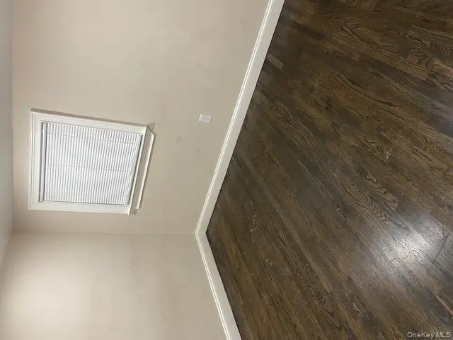 Spare room featuring dark wood-style flooring Spare room featuring dark wood-style flooring