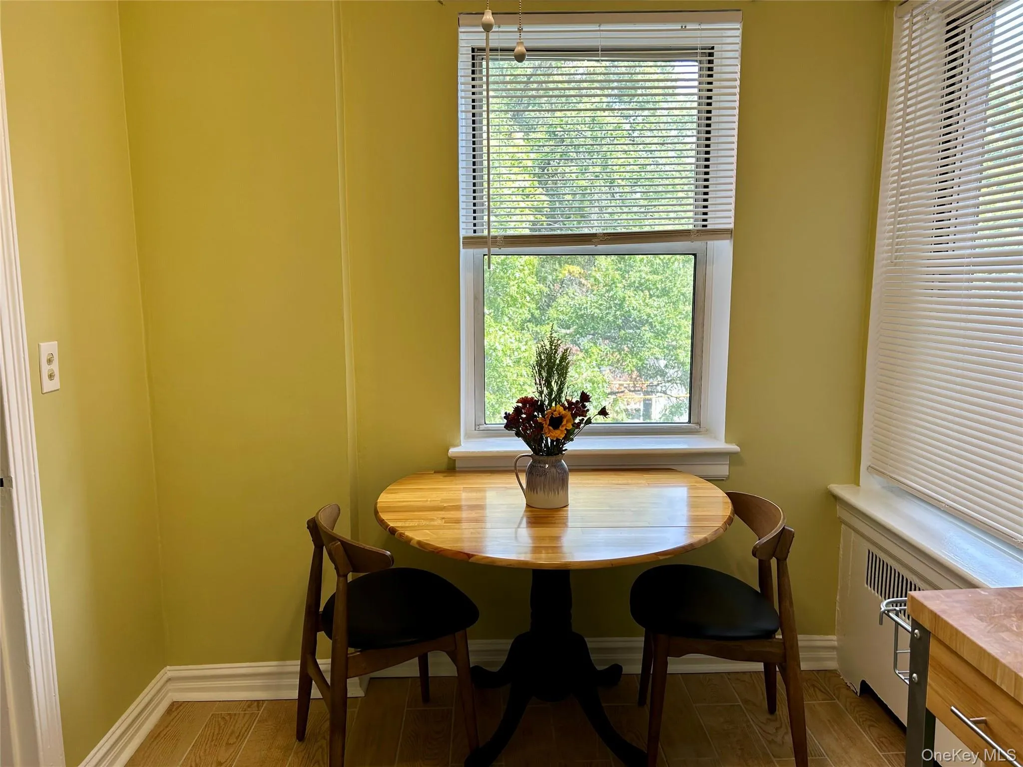 Dining space featuring tiled floors and radiator heating unit Dining space featuring tiled floors and radiator heating unit