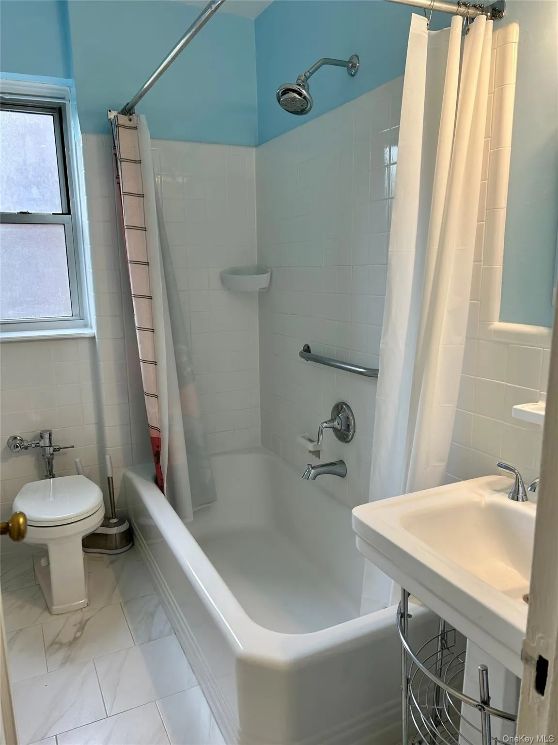 Bathroom, right outside of the bedroom, with tile walls and shower / tub combo with curtain Bathroom, right outside of the bedroom, with tile walls and shower / tub combo with curtain