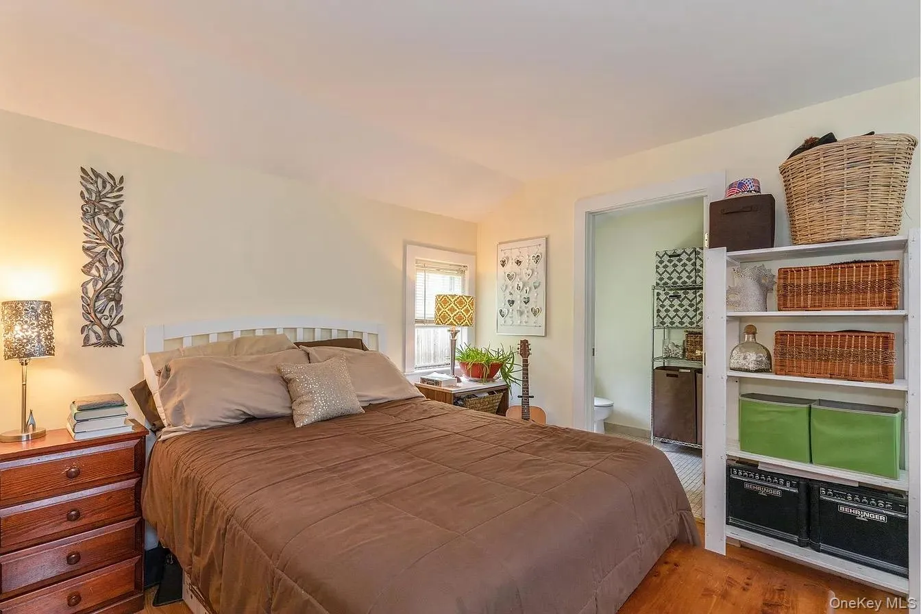 Bedroom with light wood-type flooring, lofted ceiling, and ensuite bath Bedroom with light wood-type flooring, lofted ceiling, and ensuite bath