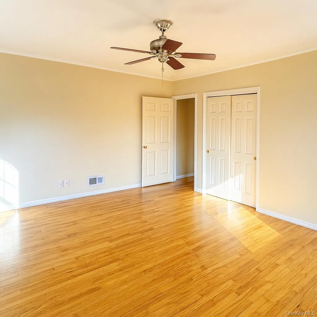 Unfurnished bedroom featuring light wood-style floors, ornamental molding, a ceiling fan, and a closet Unfurnished bedroom featuring light wood-style floors, ornamental molding, a ceiling fan, and a closet