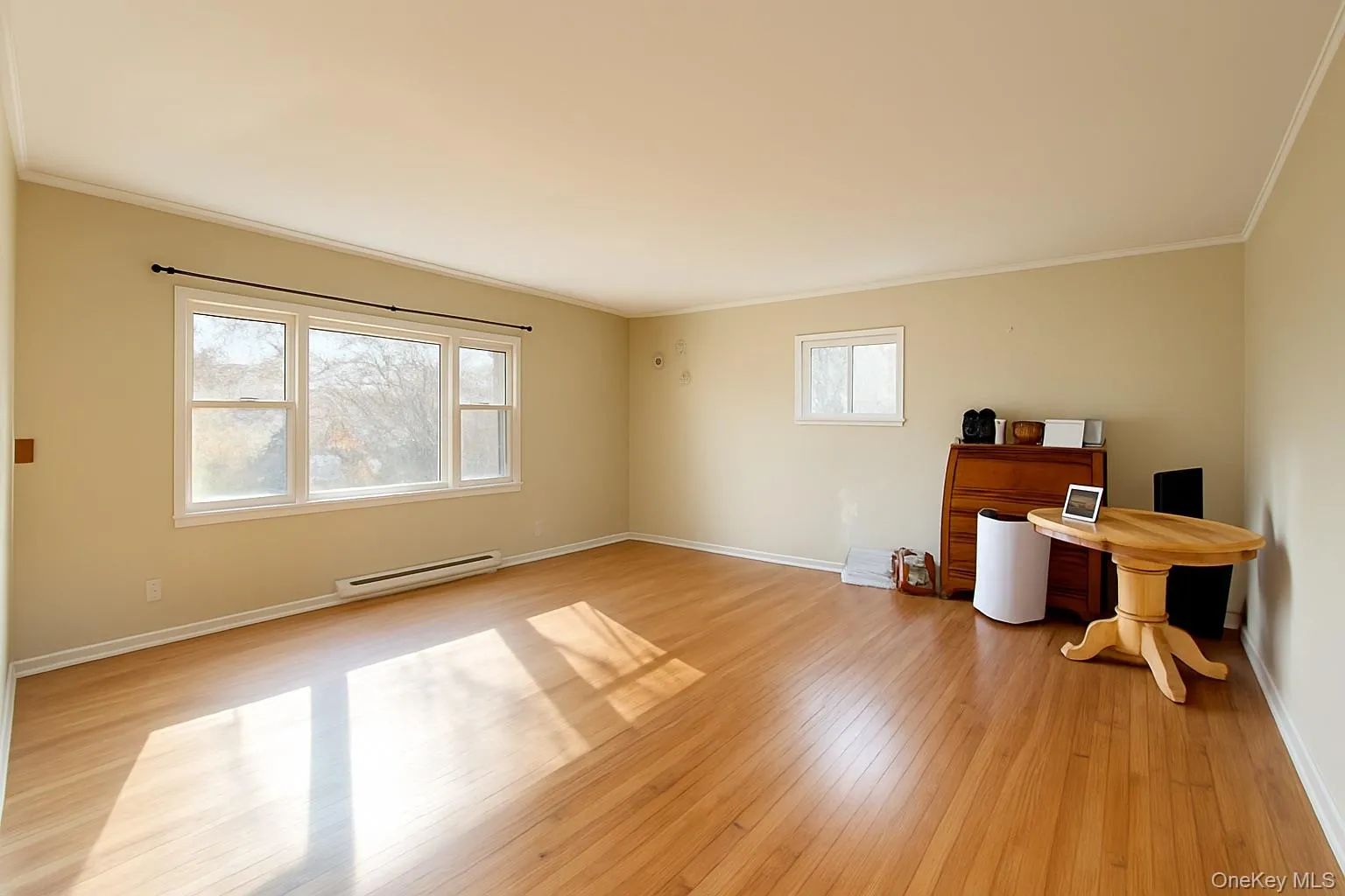 Unfurnished room with crown molding, a baseboard heating unit, and light wood-type flooring Unfurnished room with crown molding, a baseboard heating unit, and light wood-type flooring