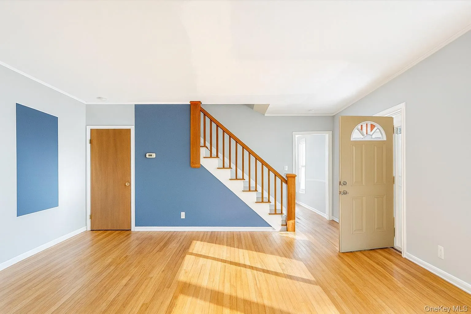 Entryway featuring stairway, light wood-type flooring, and ornamental molding Entryway featuring stairway, light wood-type flooring, and ornamental molding